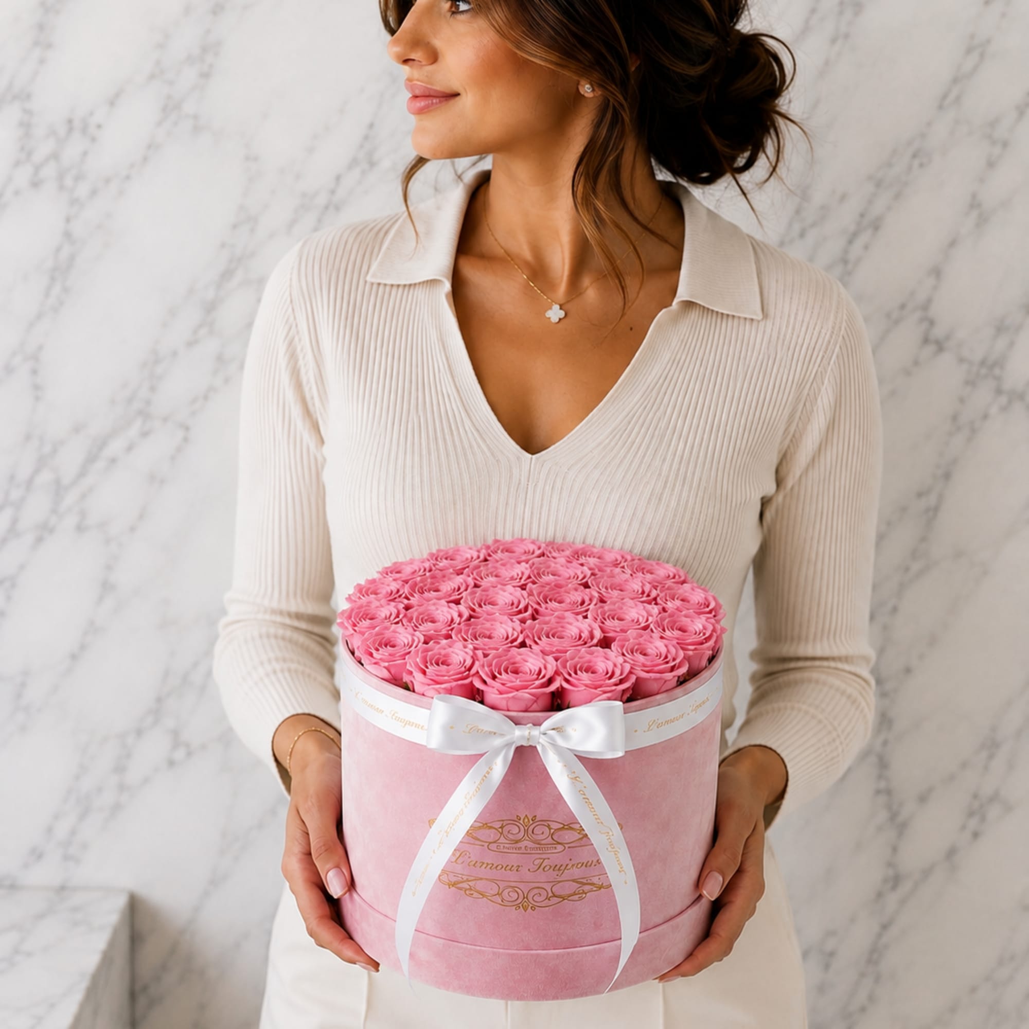 Woman holding a pink hatbox filled with pink roses and tied with a white ribbon