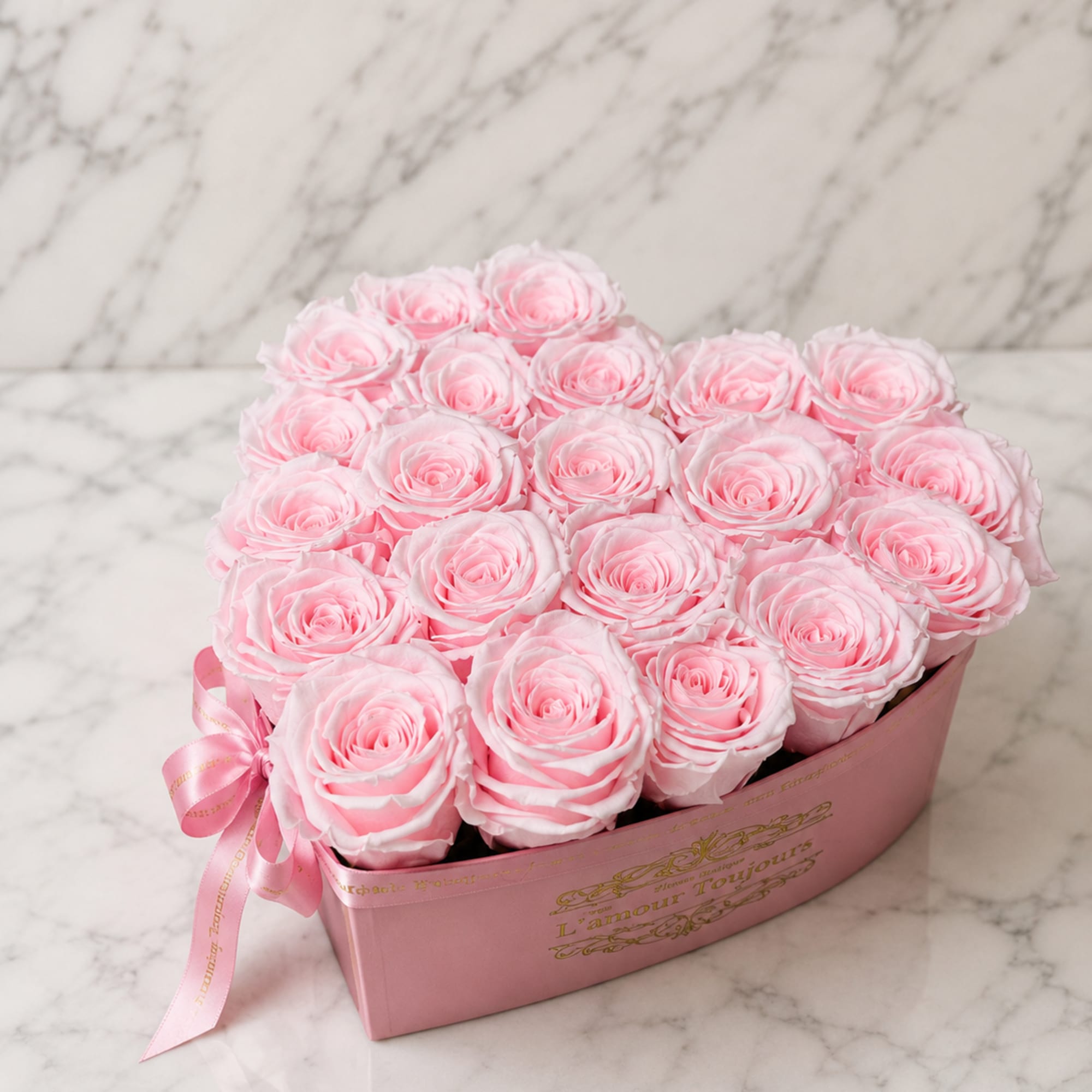Pink roses arranged in a pink gift box with a ribbon