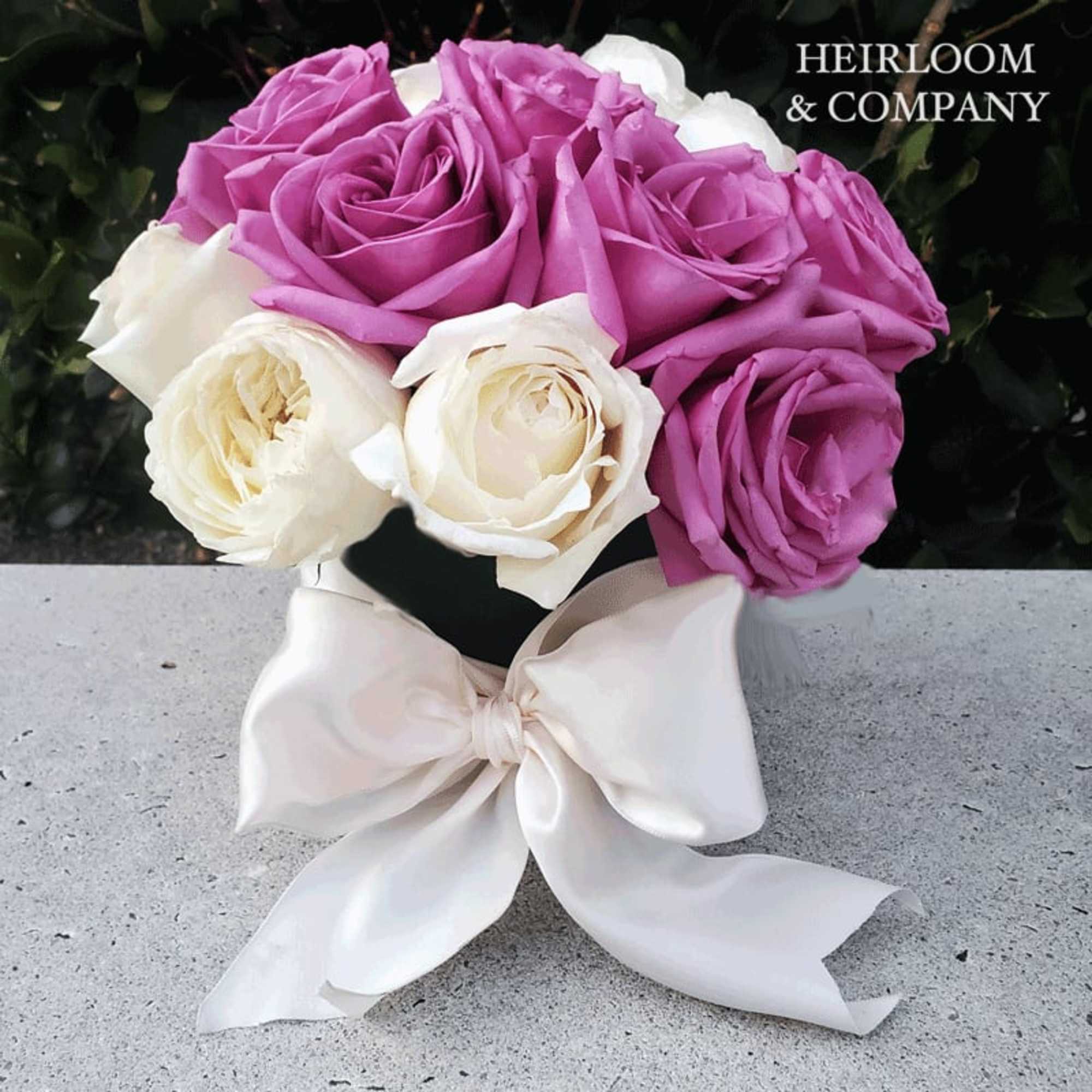 Bouquet of lavender and white roses tied with a white ribbon
