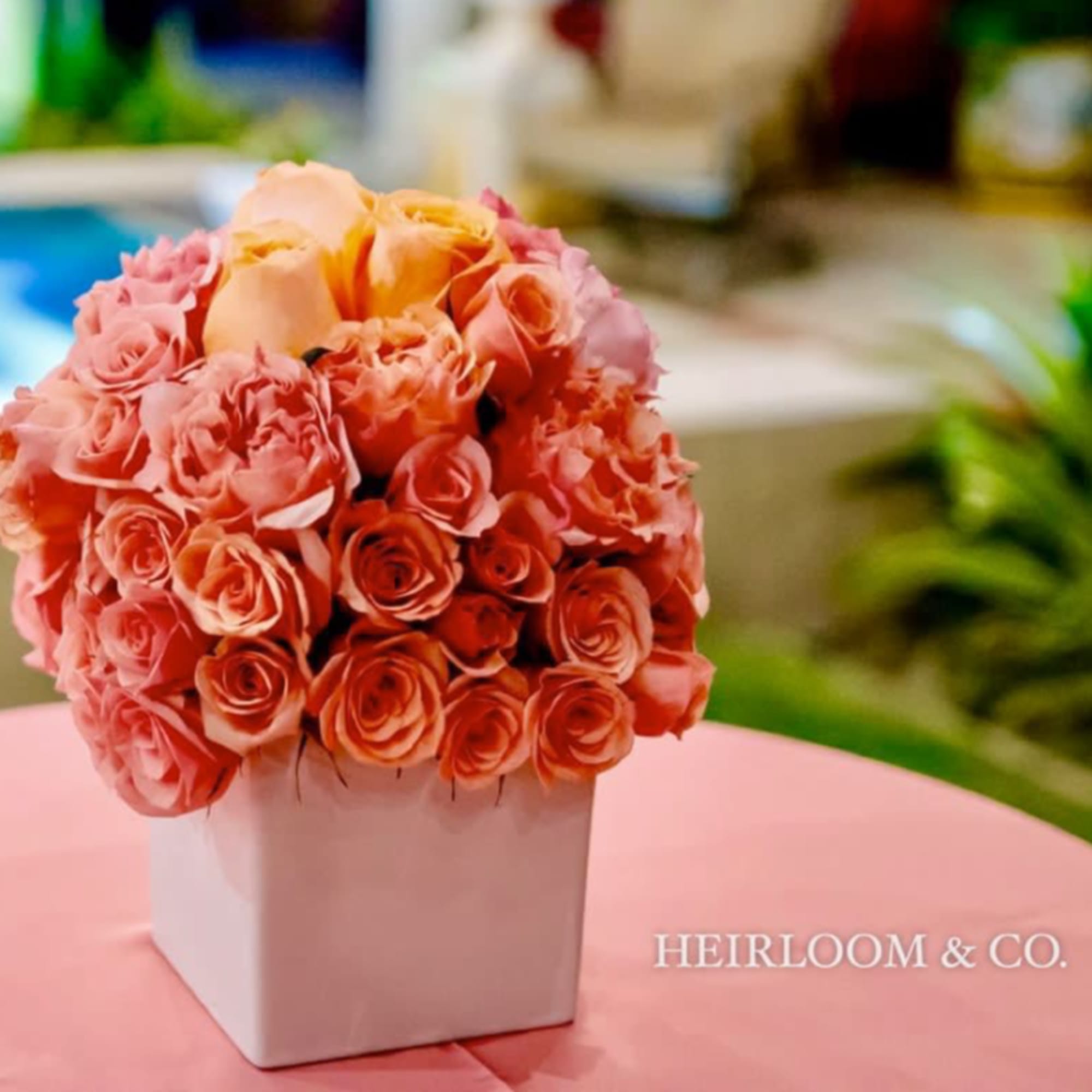 Peach and pink rose bouquet in a white square vase