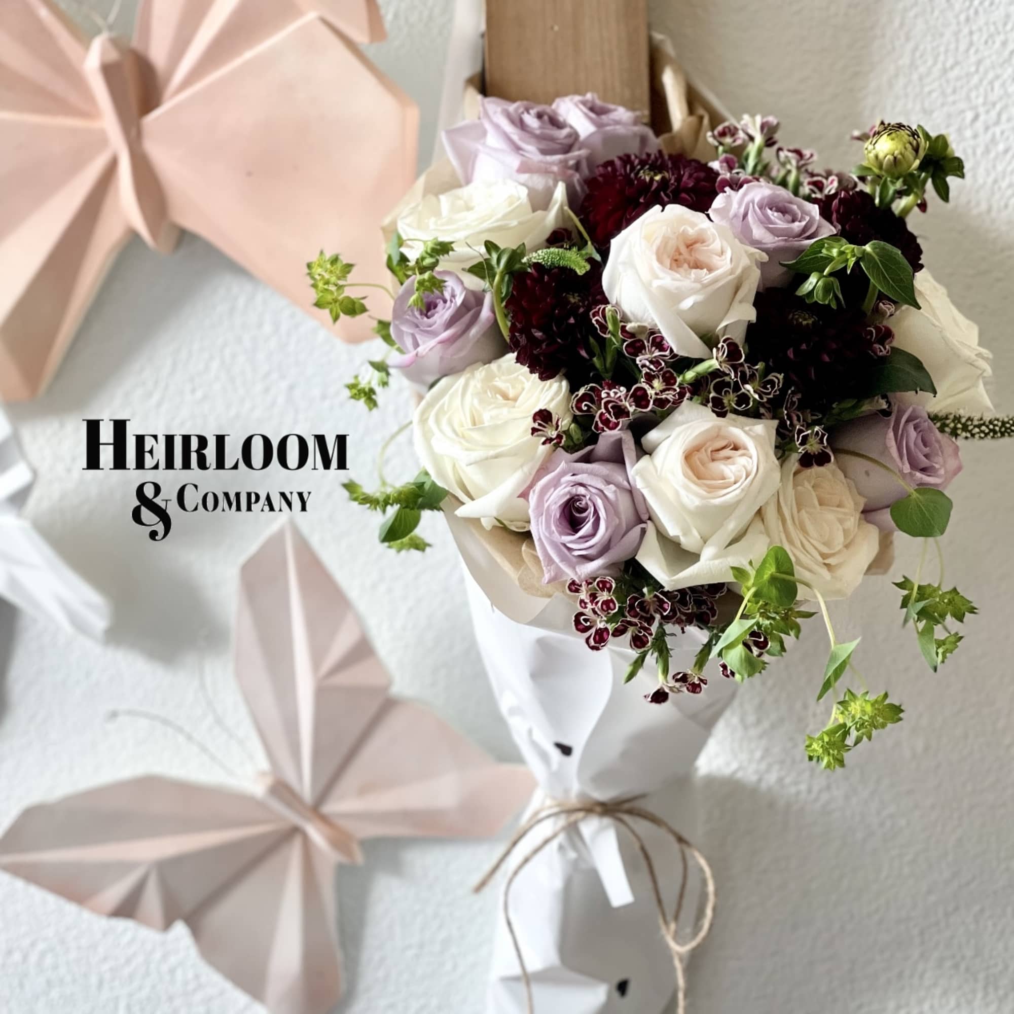 Bouquet of white and lavender roses with dark burgundy accents