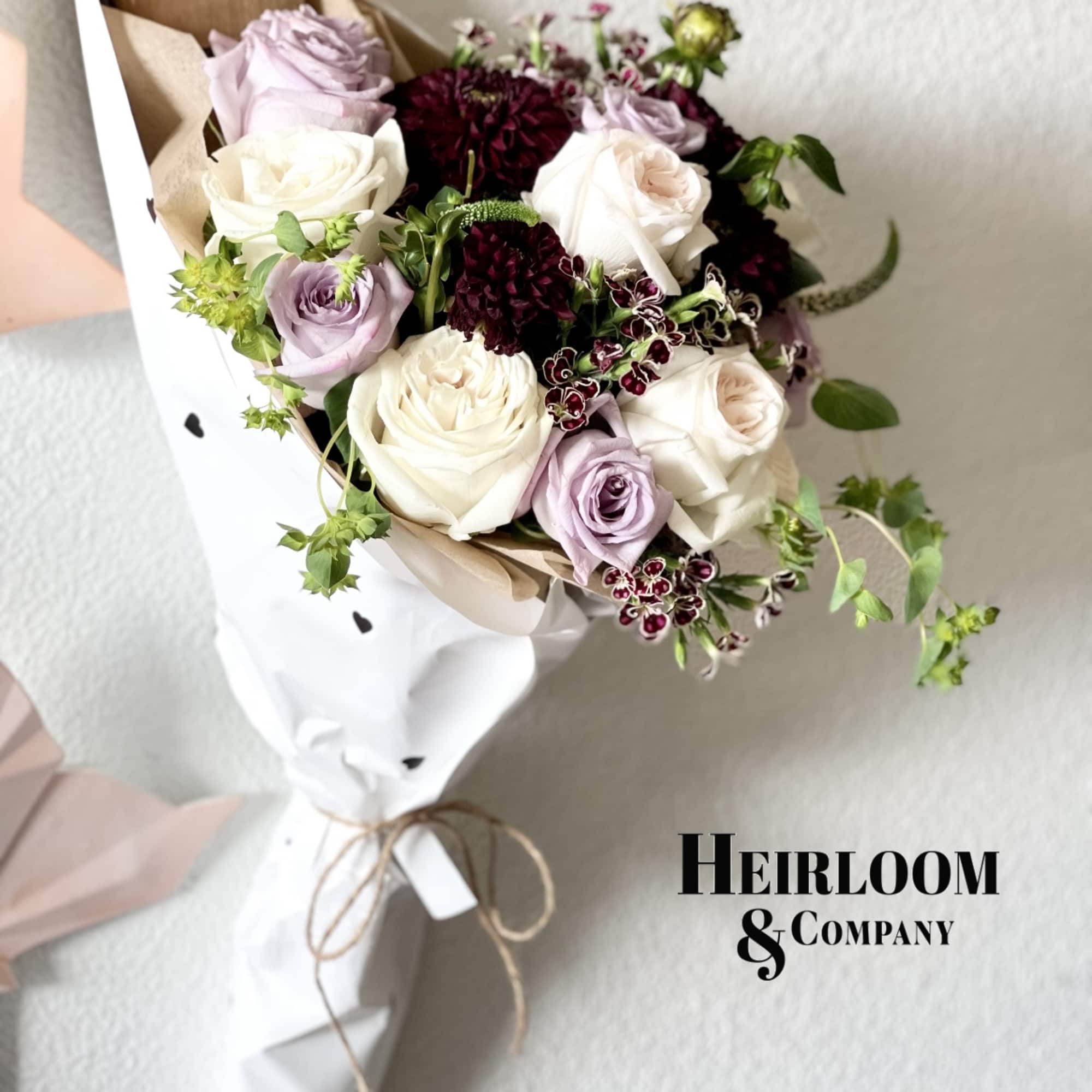 Hand-tied bouquet of white, lavender, and burgundy roses