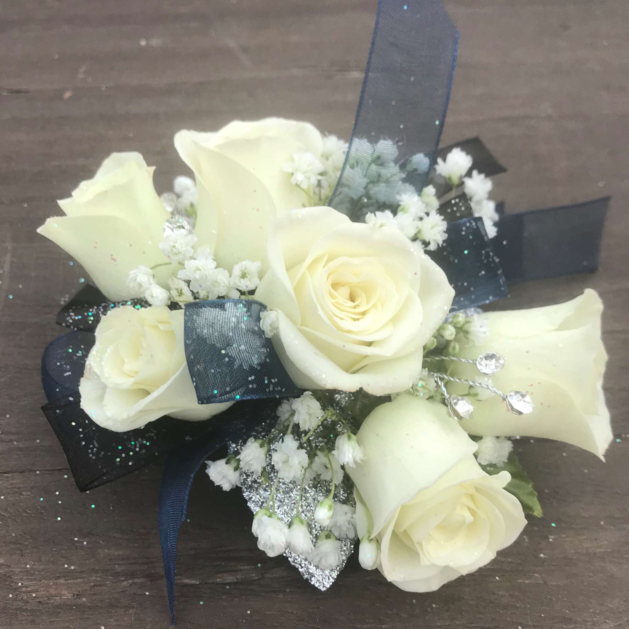 Small bouquet of white roses and baby's breath with dark ribbon