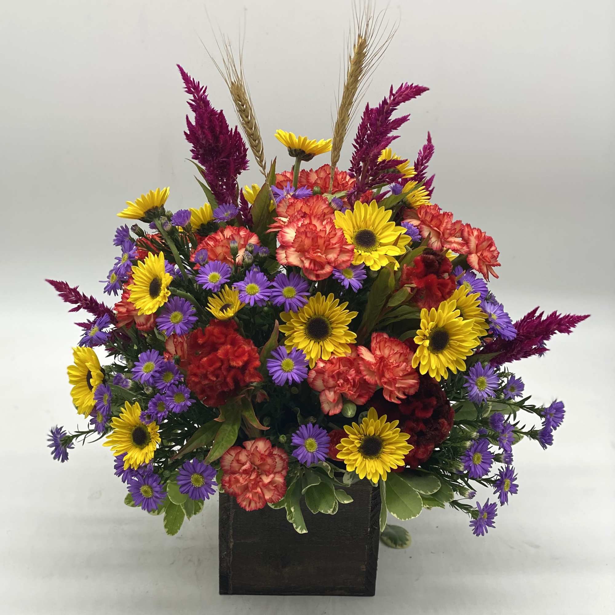A bright mix of fresh, fall toned flowers designed in a wooden, photo 2 of 3