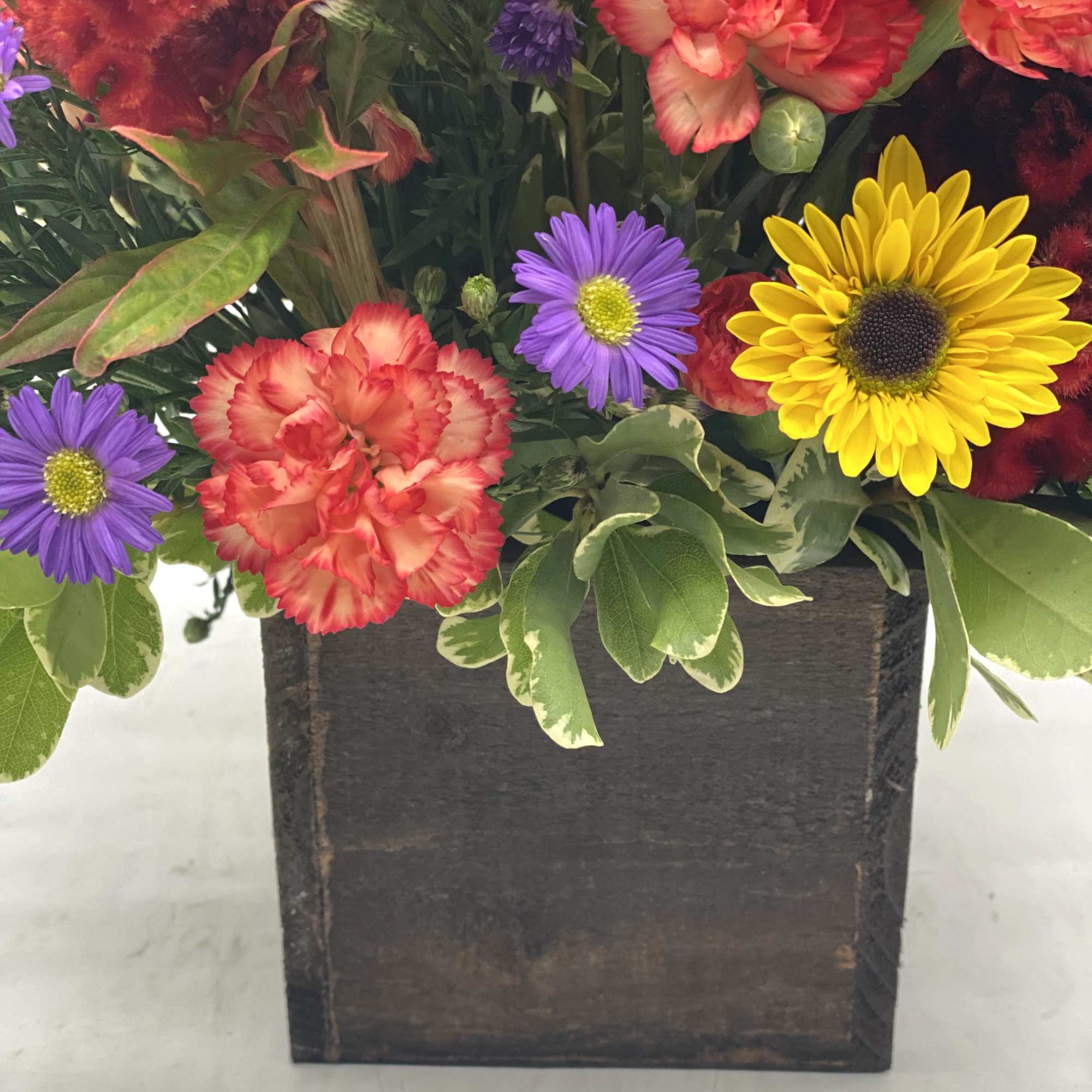 A bright mix of fresh, fall toned flowers designed in a wooden, photo 3 of 3