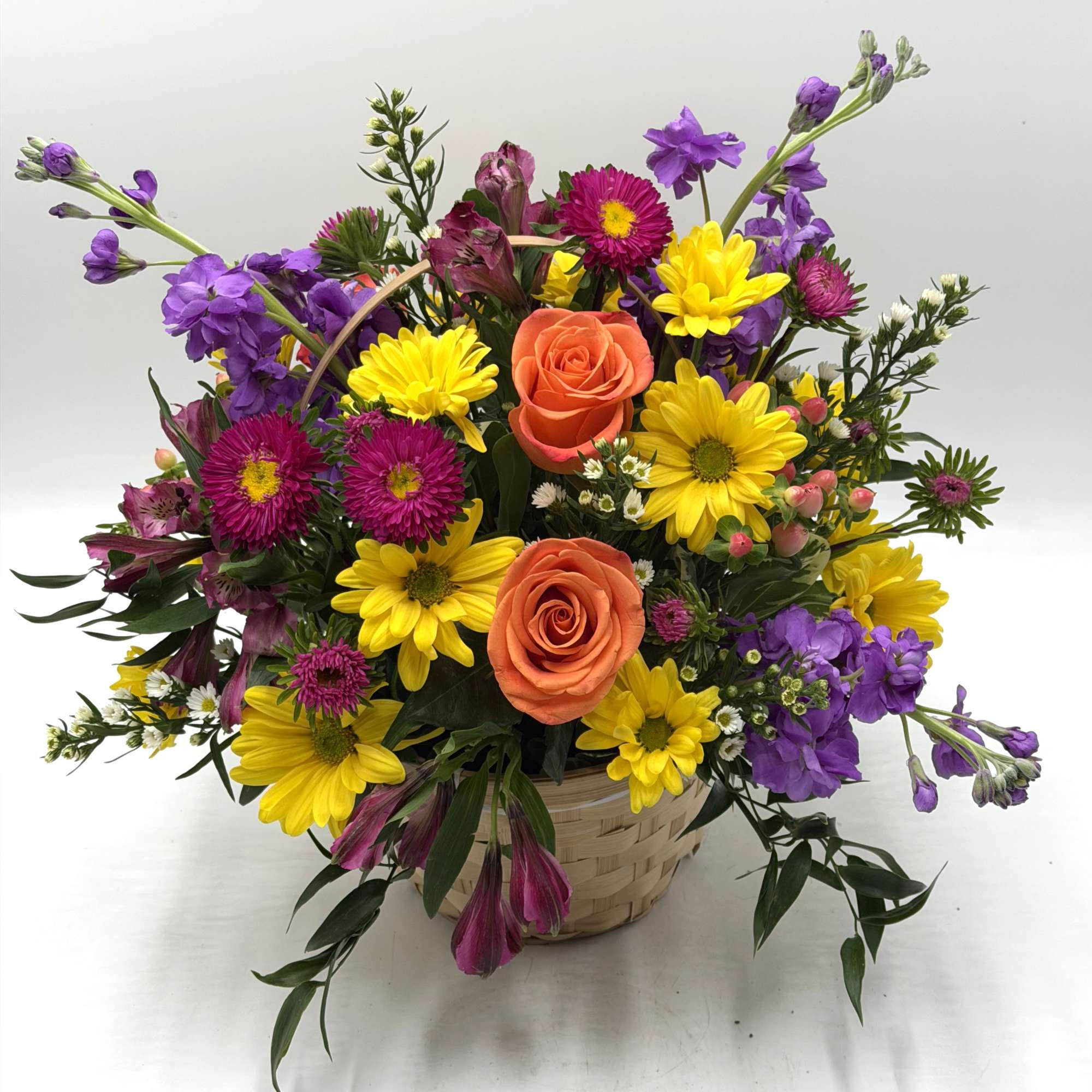 A mix of fresh, seasonal blooms designed in a handled wicker basket., photo 2 of 7