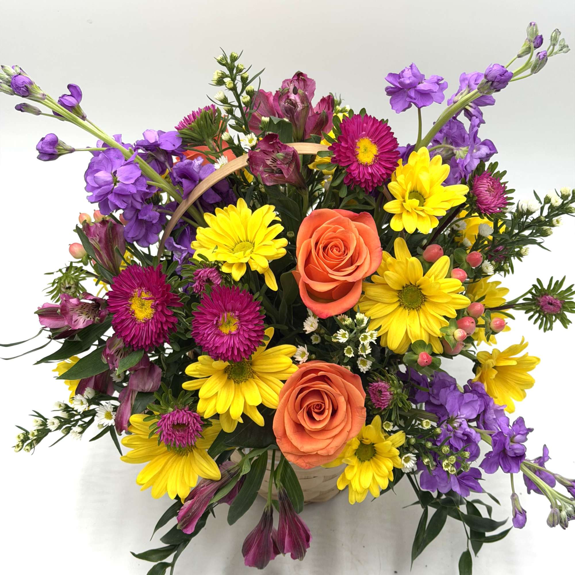 A mix of fresh, seasonal blooms designed in a handled wicker basket., photo 3 of 7
