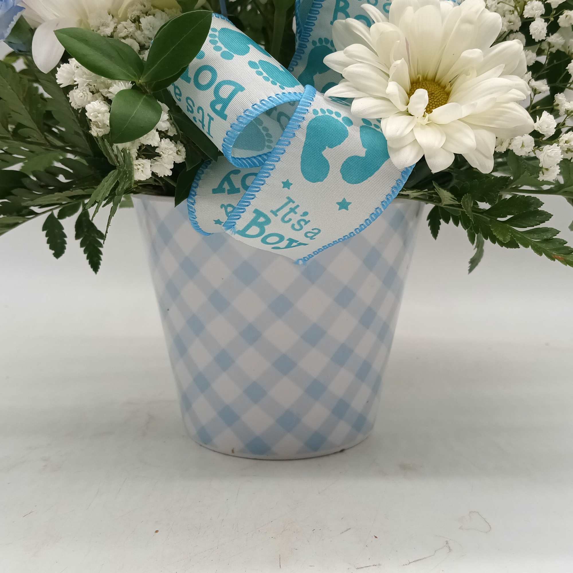 White daisy bouquet in a blue checkered pot with a baby boy ribbon