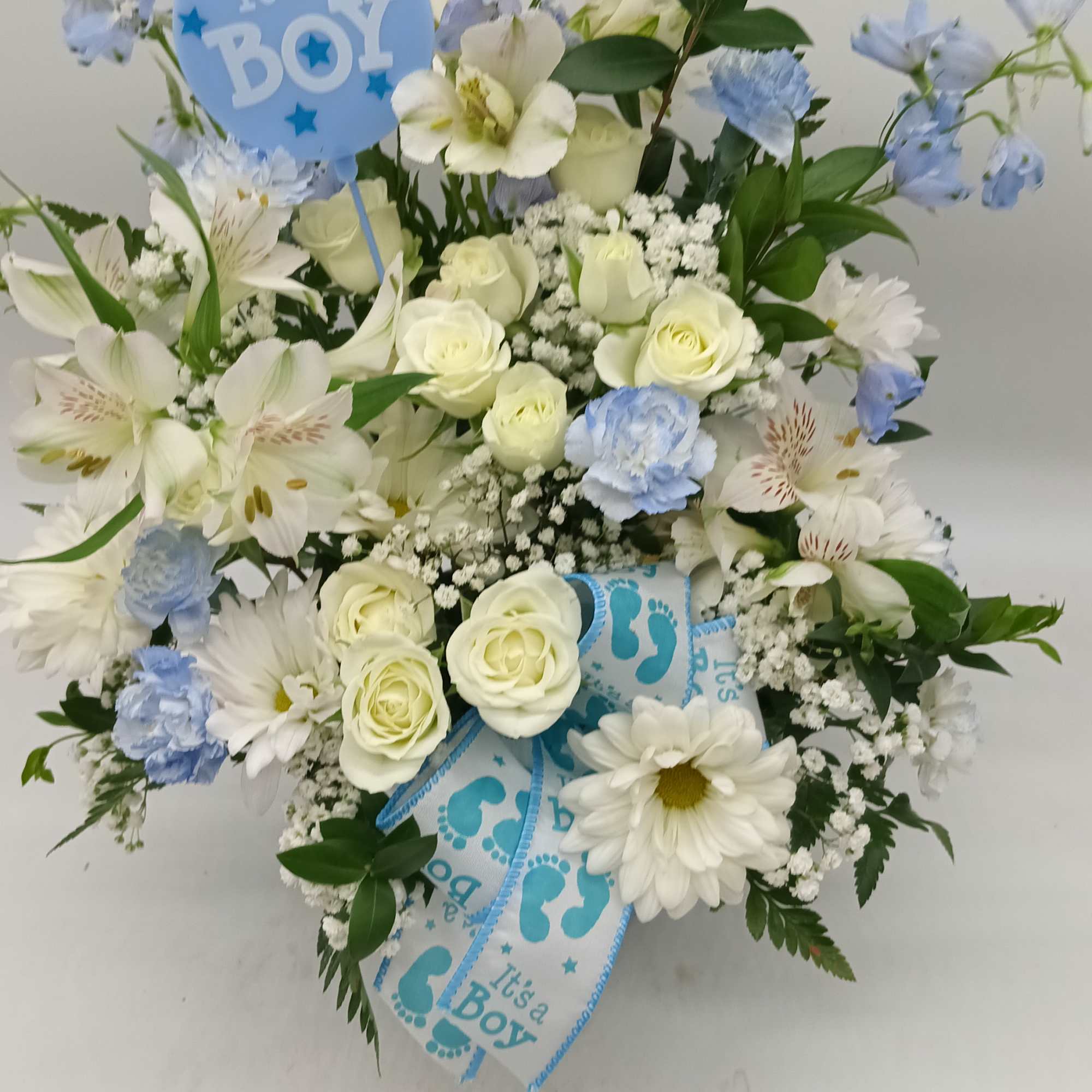 Blue and white flower arrangement with an "It's a Boy" pick and ribbon