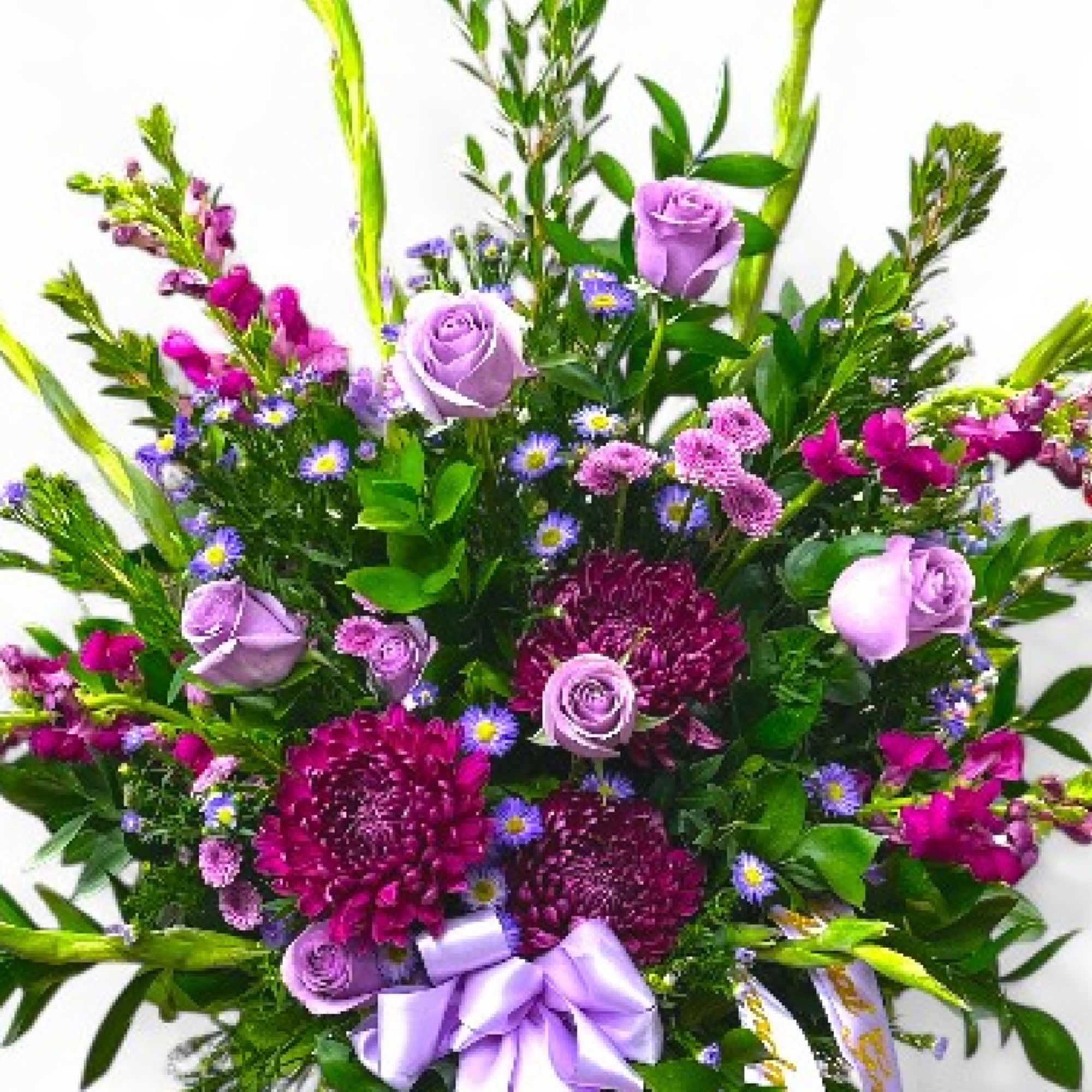 Lavender roses and purple flowers in a mixed bouquet with a ribbon