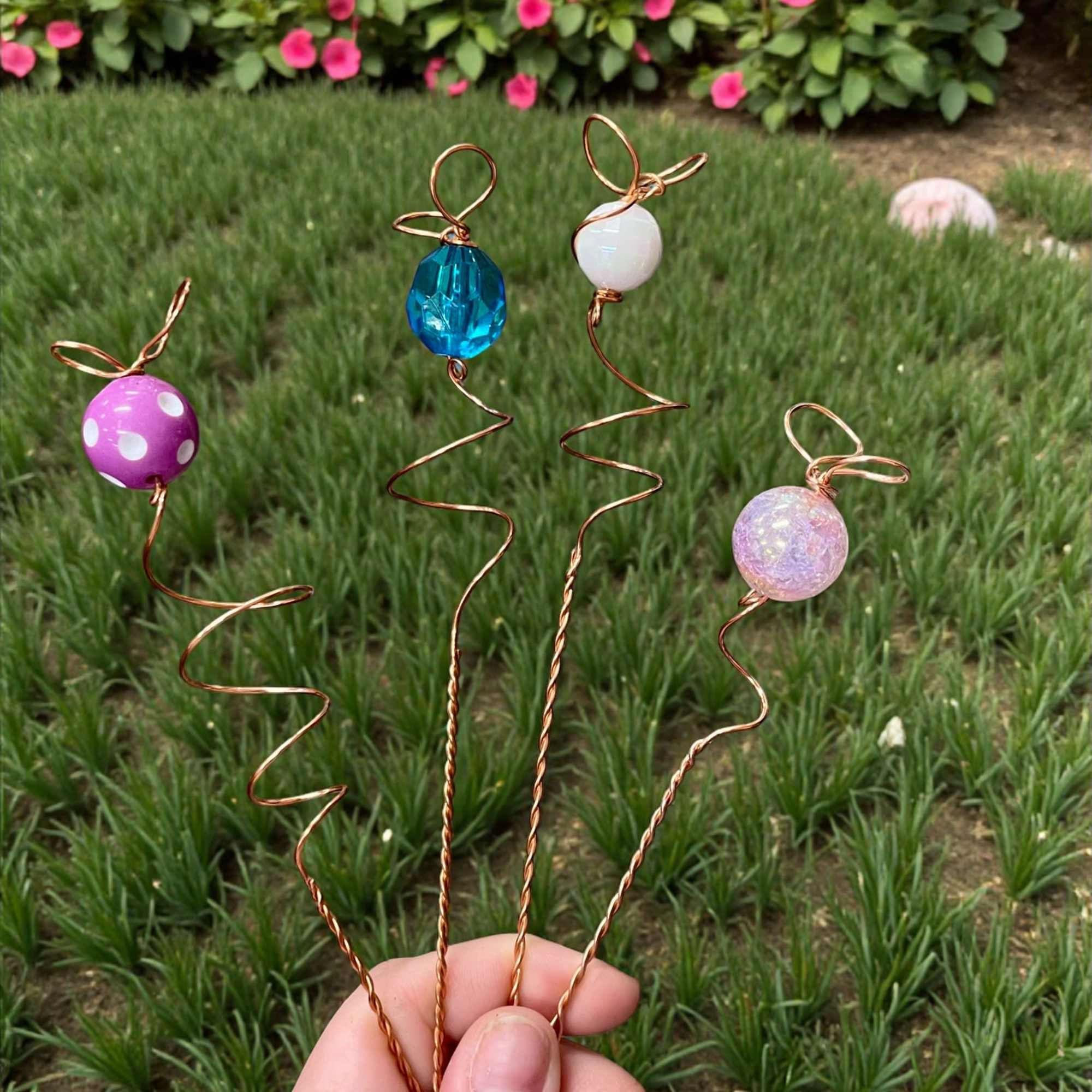 Hand holding four wire flower picks with colorful beads