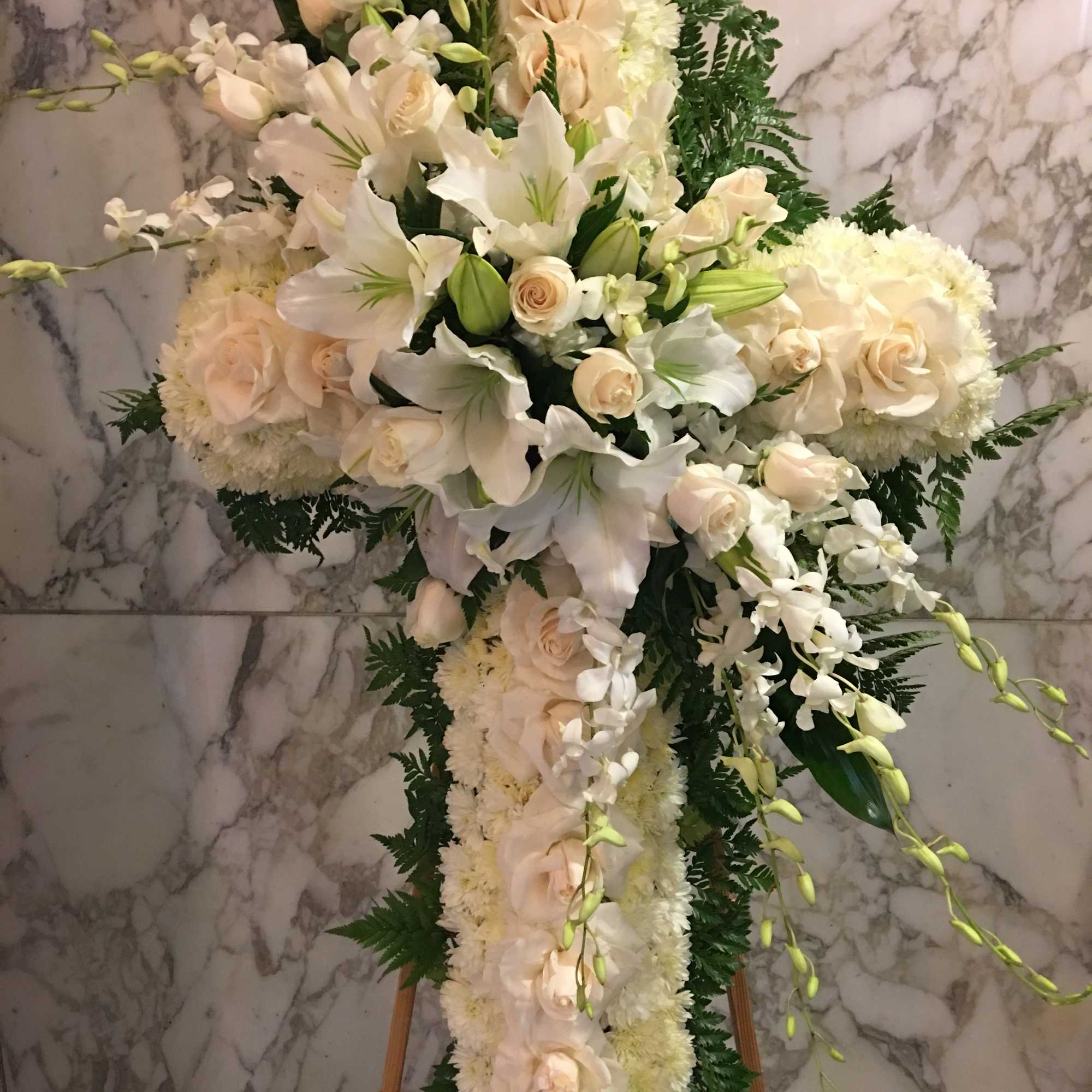 White floral cross arrangement on an easel with roses and lilies, photo 2 of 4