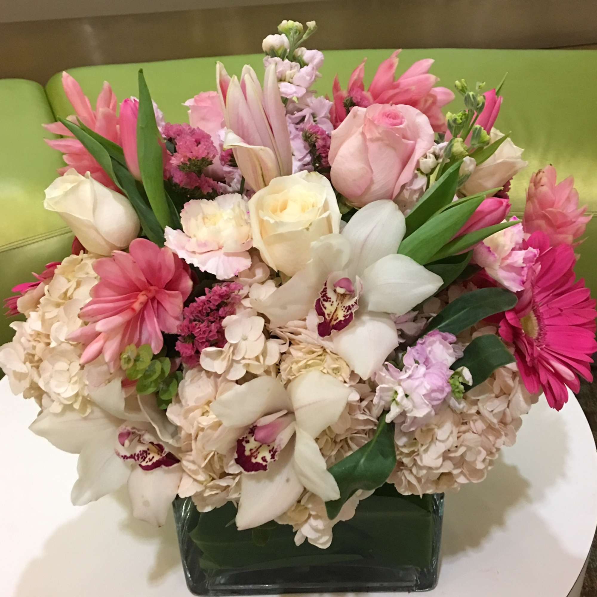Pink and white mixed flower arrangement in a square glass vase