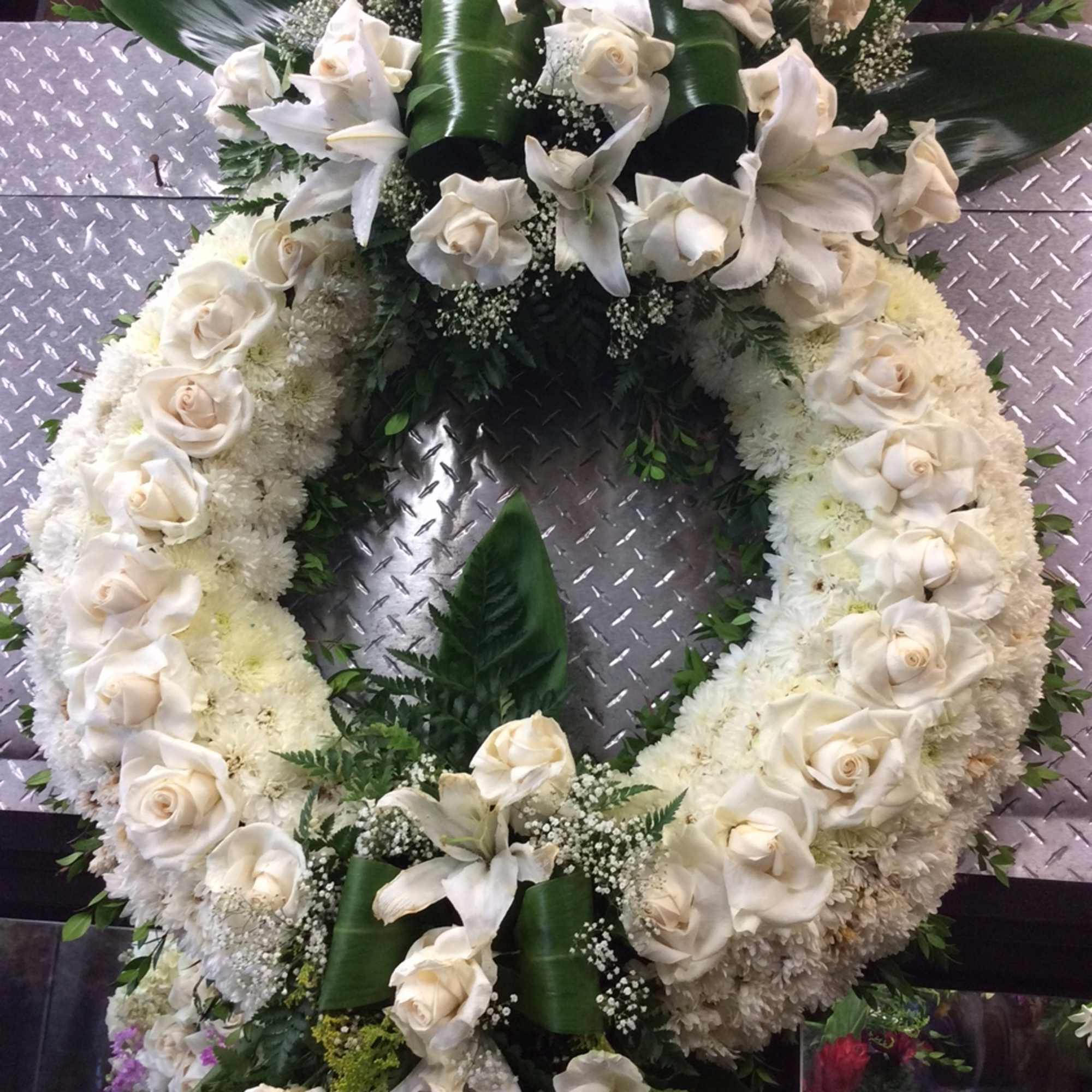 White floral funeral wreath with roses and lilies