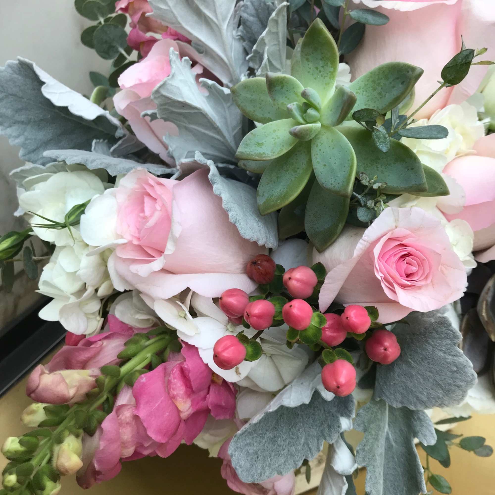 Bouquet of pink roses, white blooms, and a green succulent