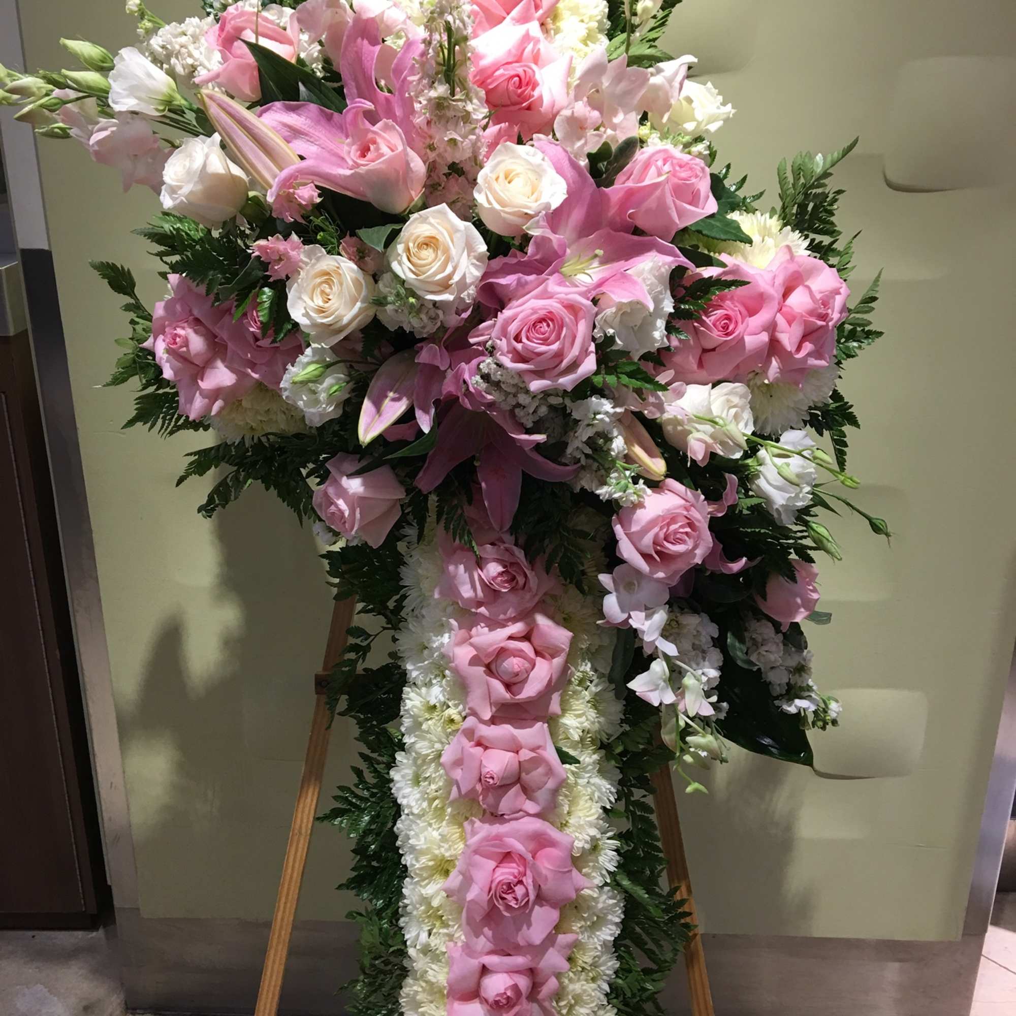 Large pink and white floral standing spray on an easel