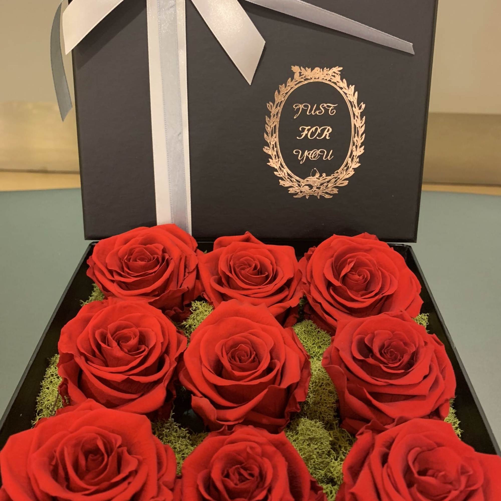 Box of red roses with a white ribbon and bow