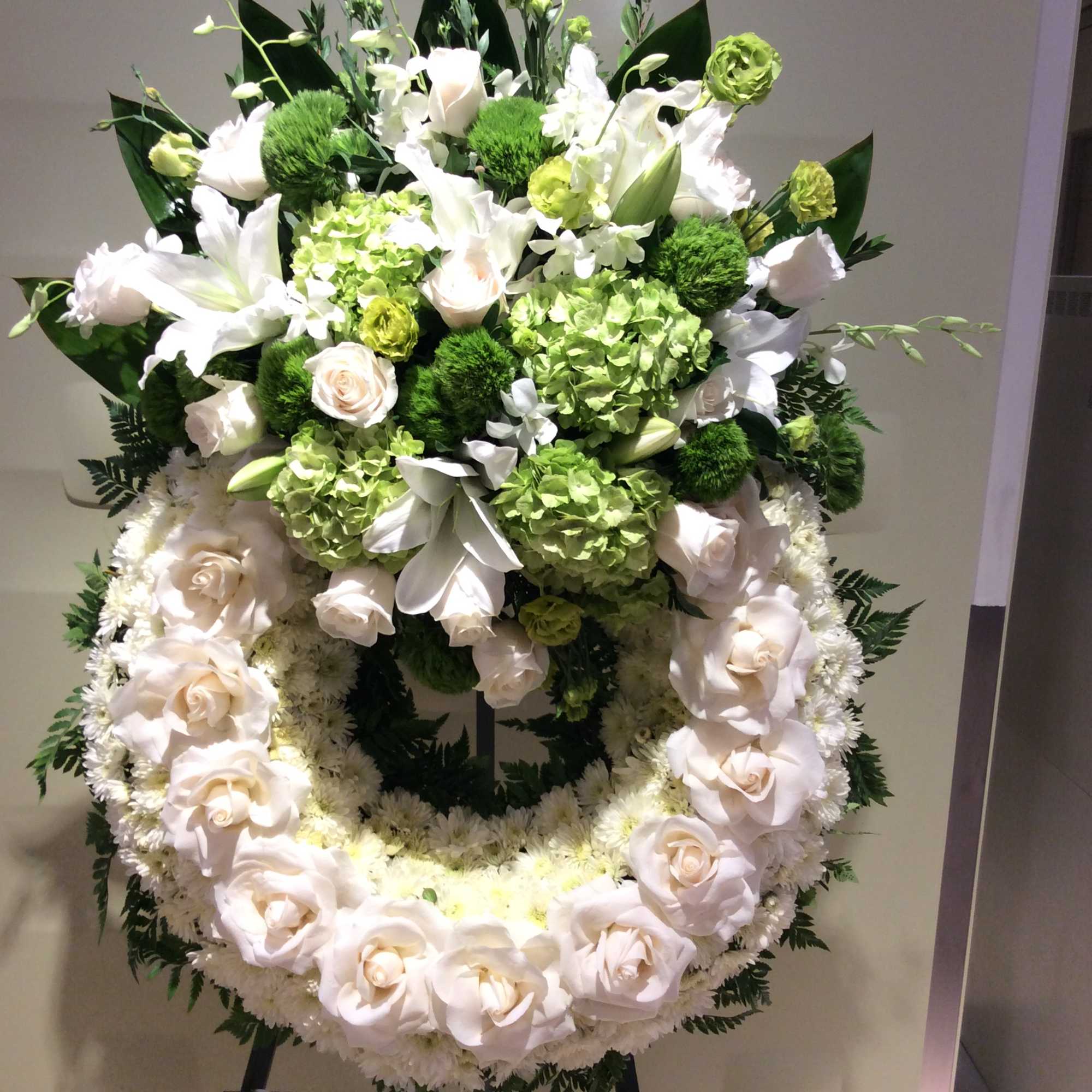 Large white and green floral wreath on an easel