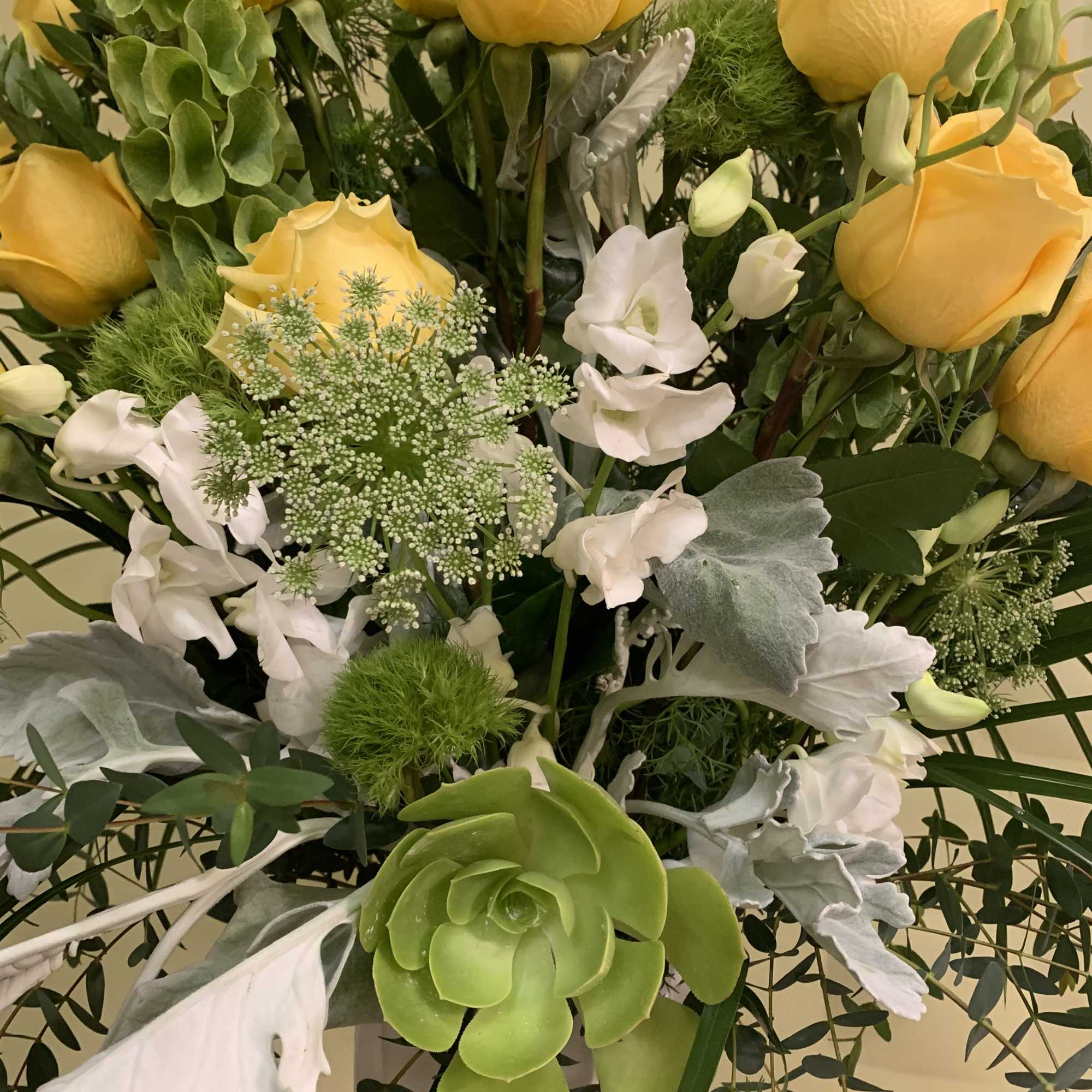 Bouquet of yellow roses with white flowers and green succulents