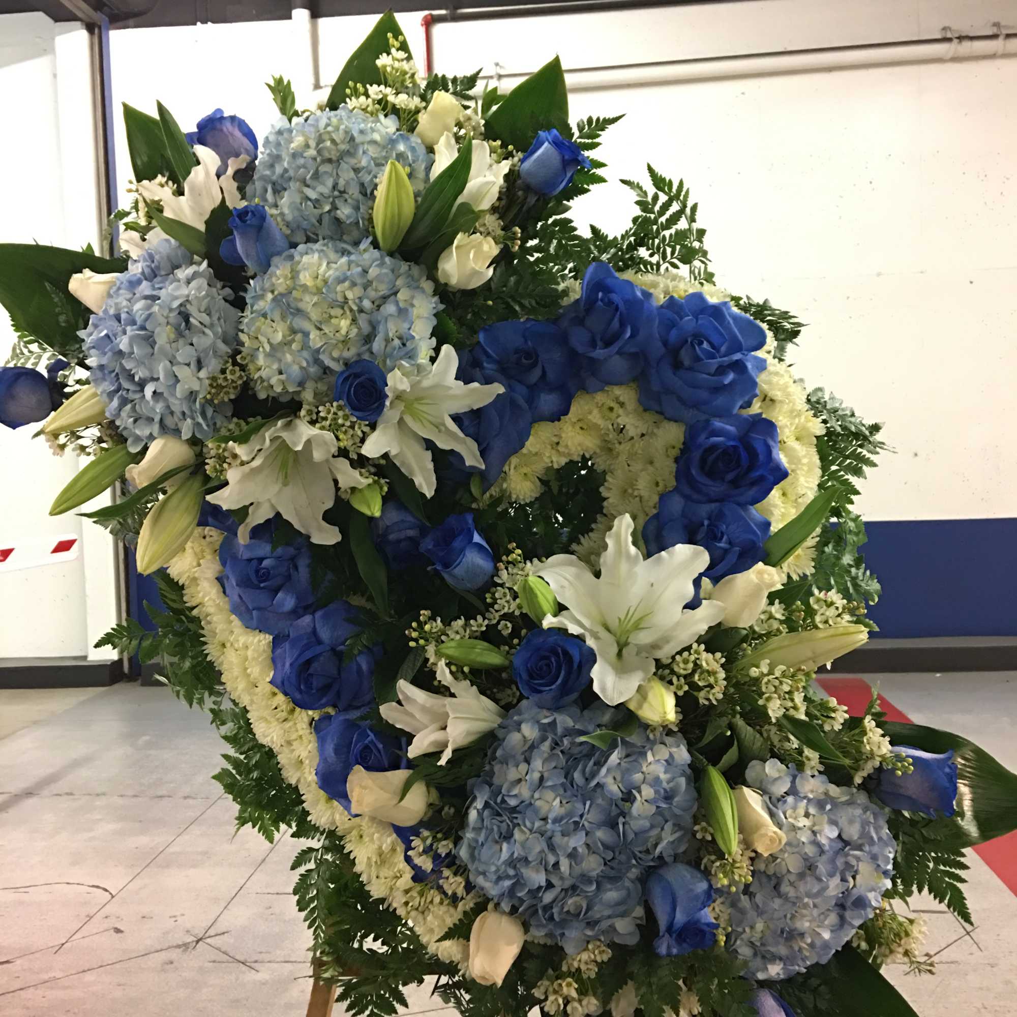 Large blue and white floral wreath on an easel