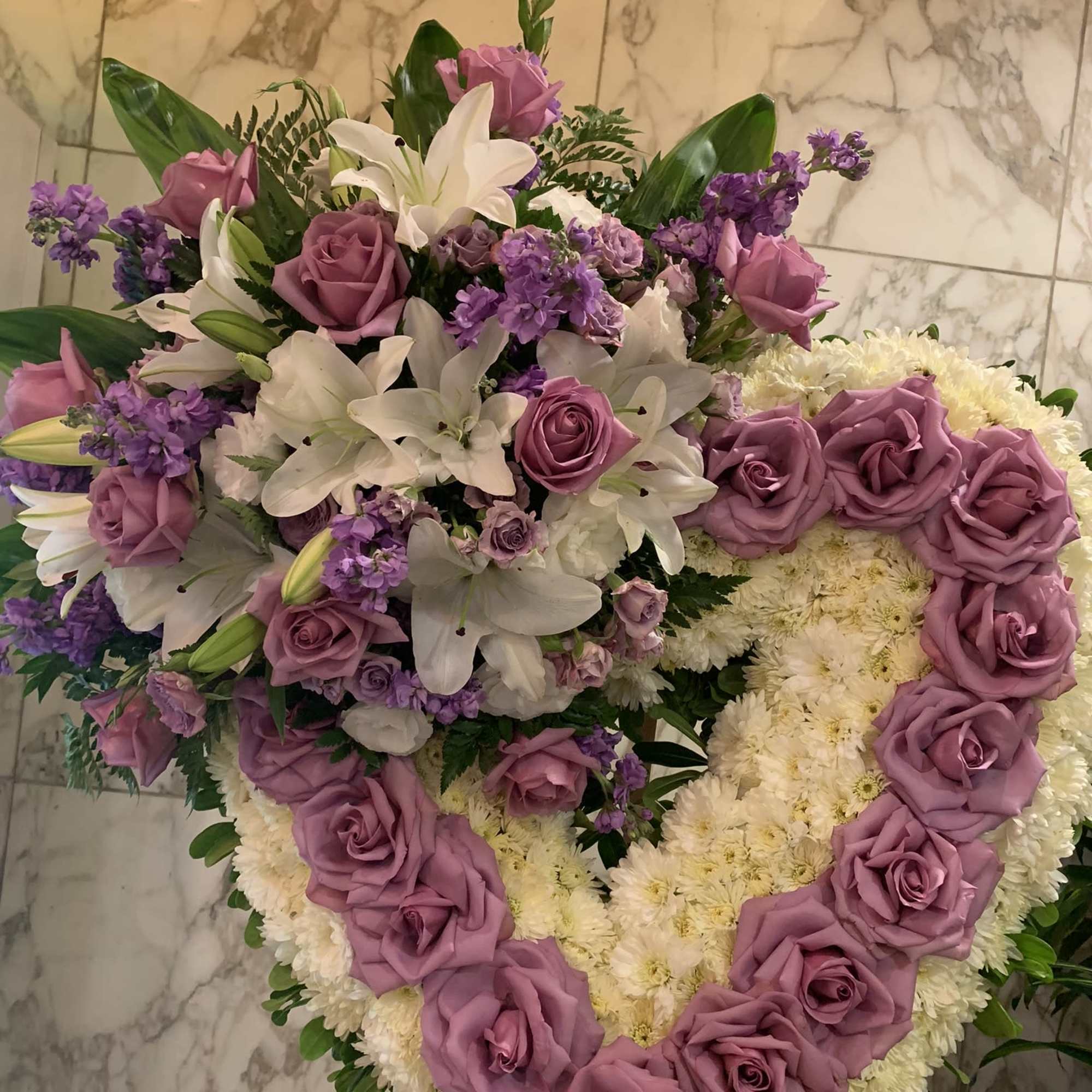 Heart-shaped floral arrangement with pink roses, white lilies, and white chrysanthemums