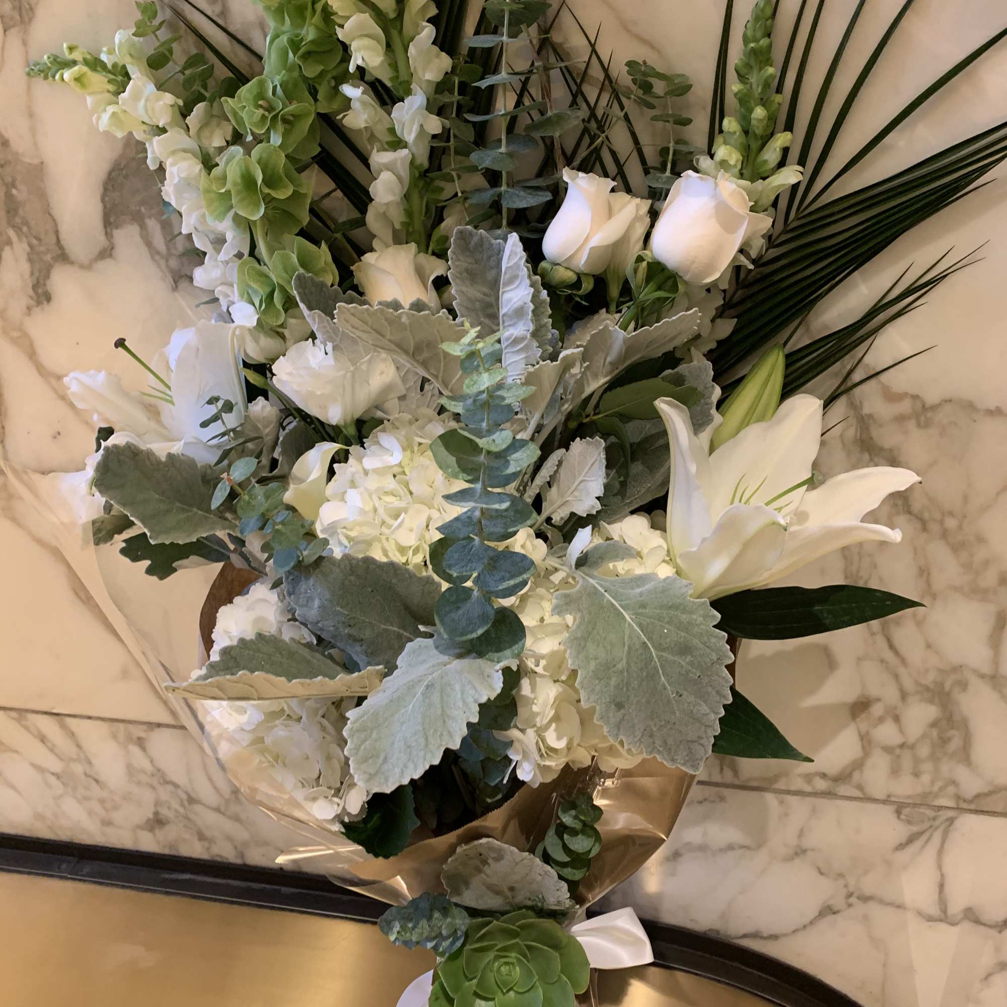 White floral bouquet with lilies, roses, and greenery