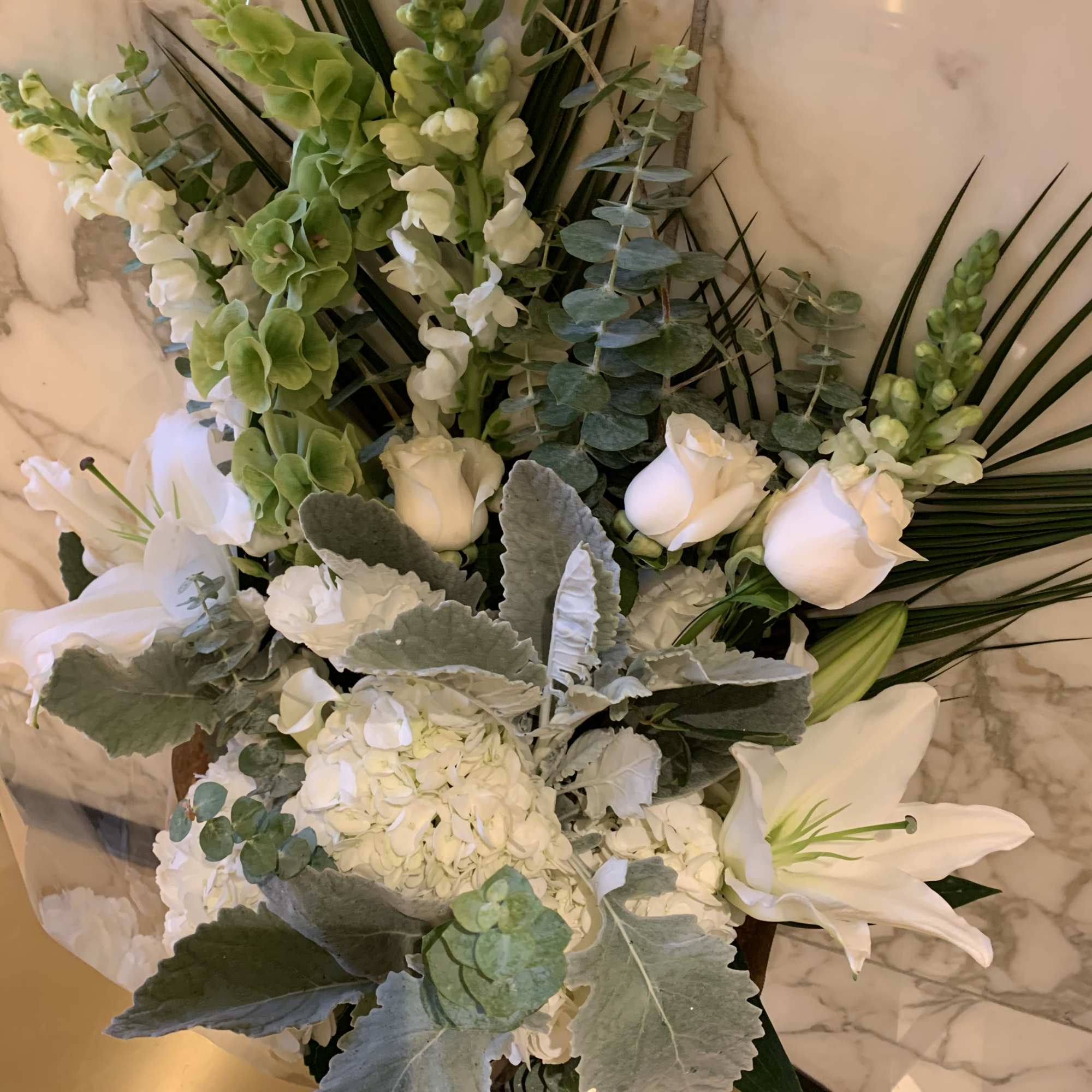 White lilies and roses with green blooms in a vase