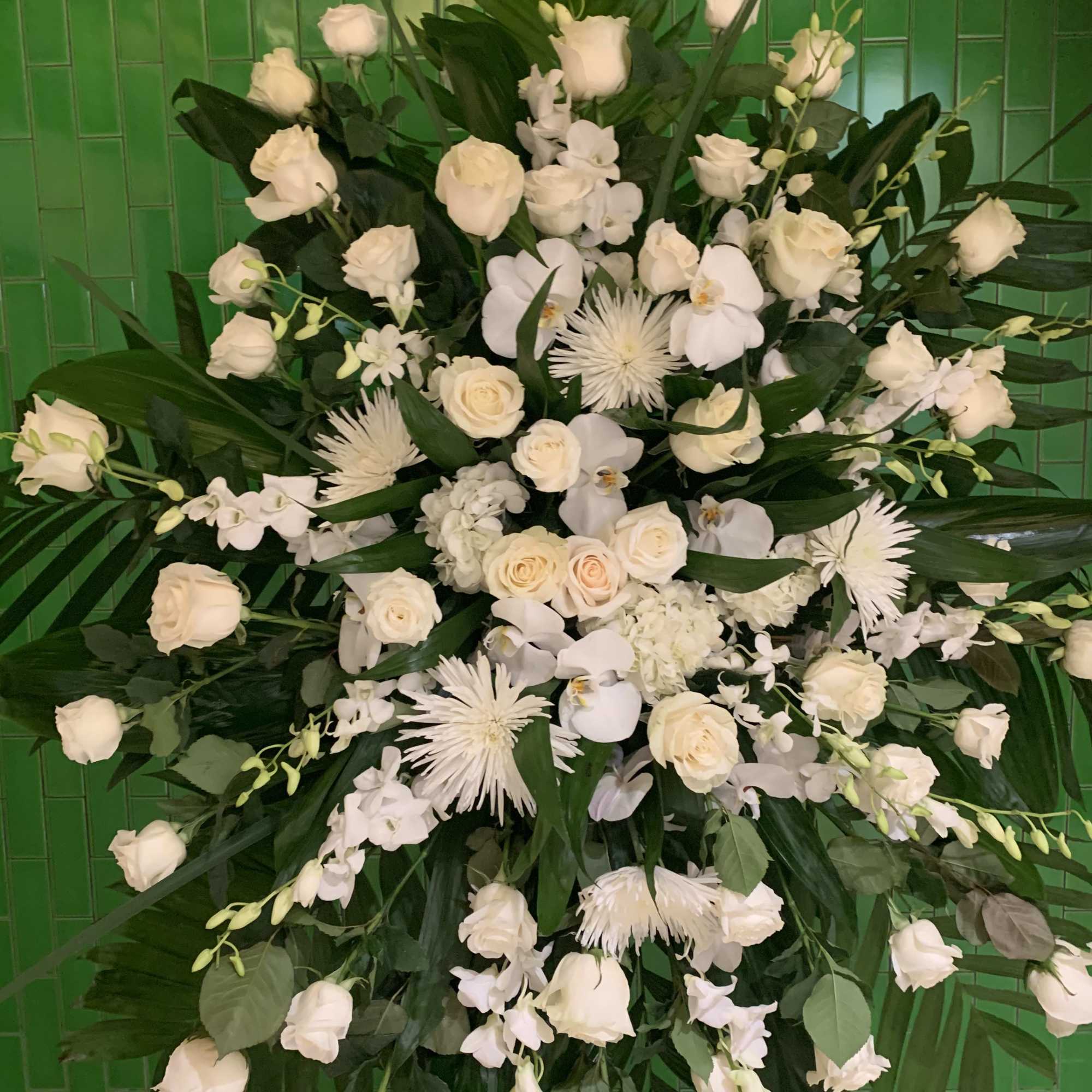 Large white floral spray with roses and orchids against green tiles, photo 2 of 4