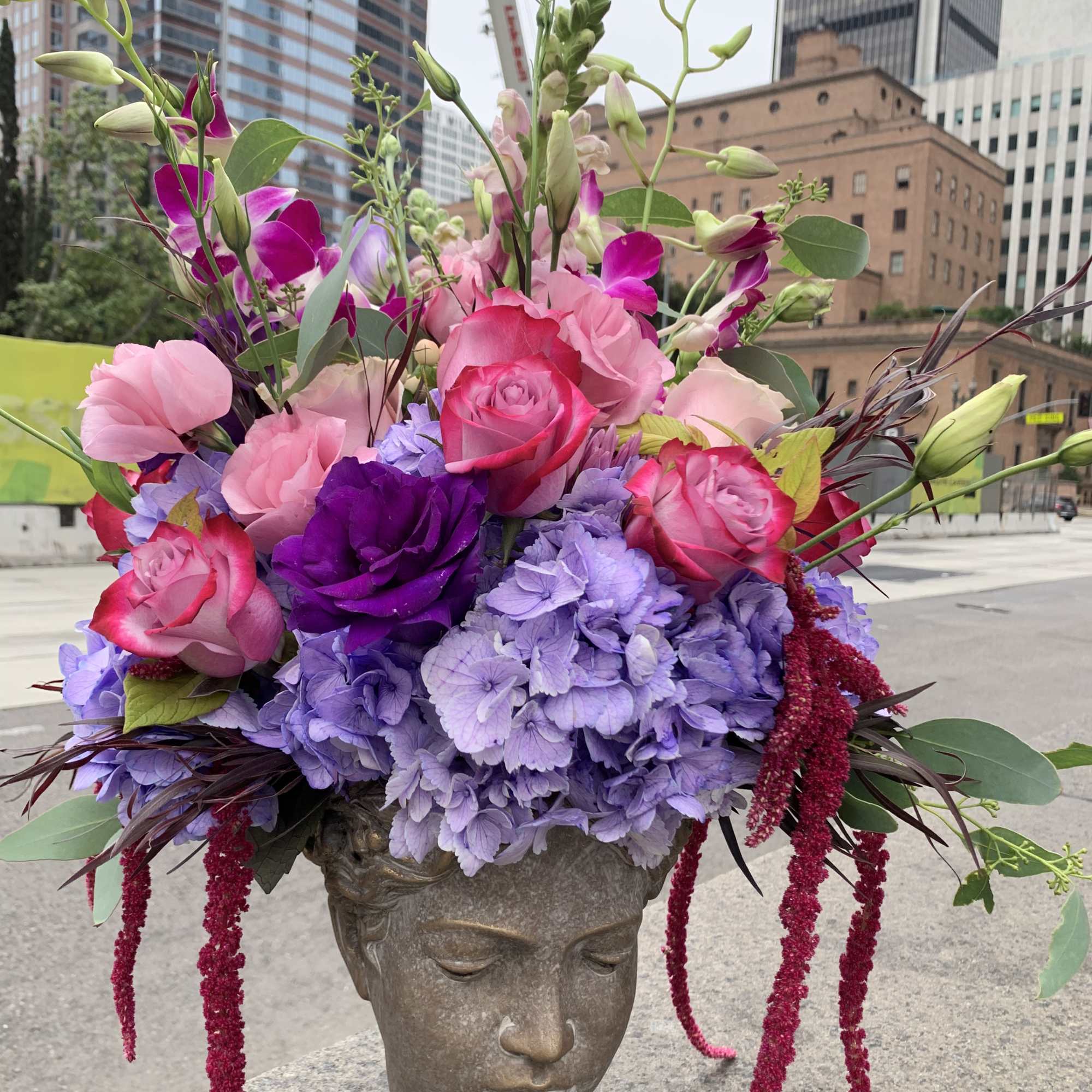 Pink and purple floral arrangement in a sculpted head vase, photo 5 of 8
