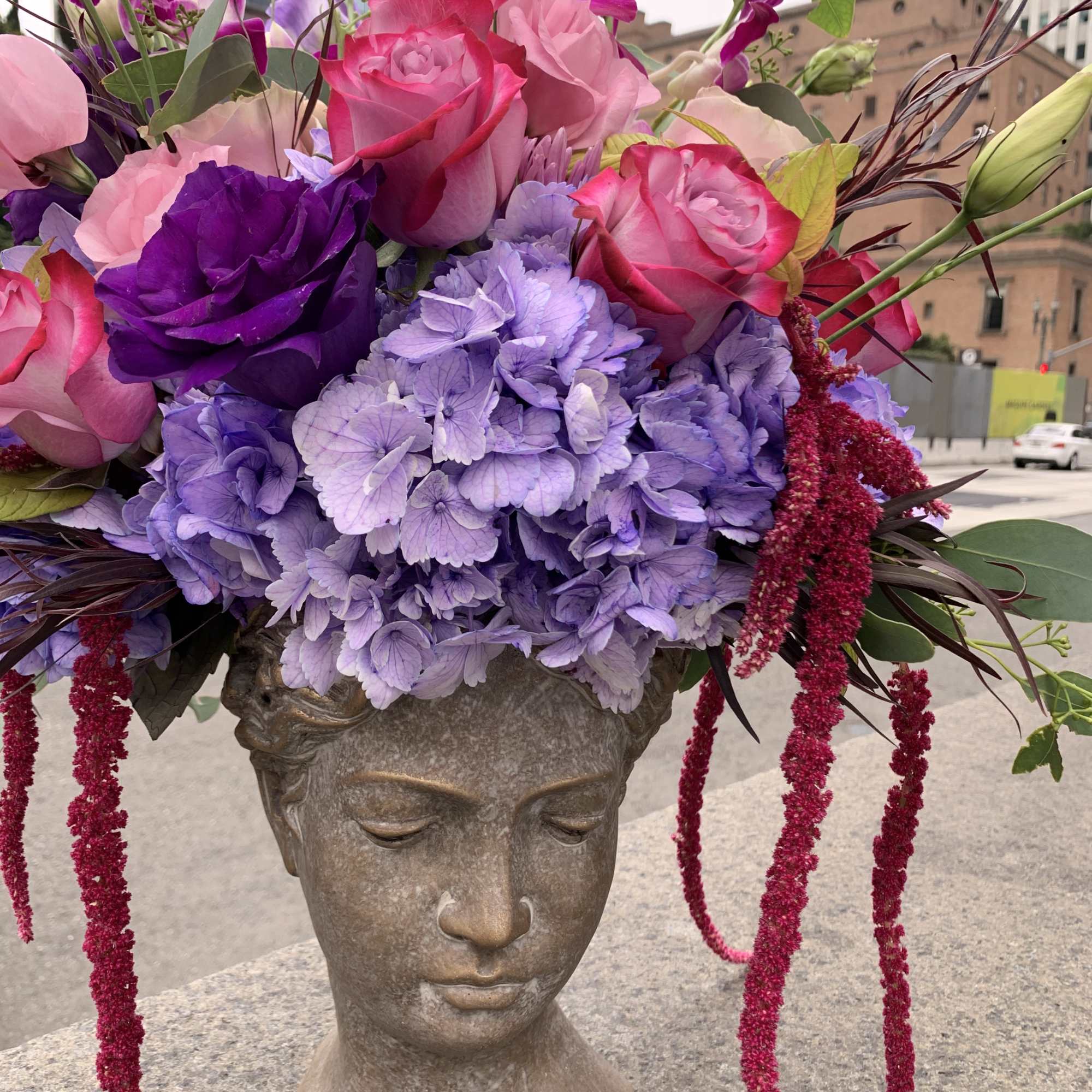 Pink and purple floral arrangement in a sculpted head vase, photo 6 of 8
