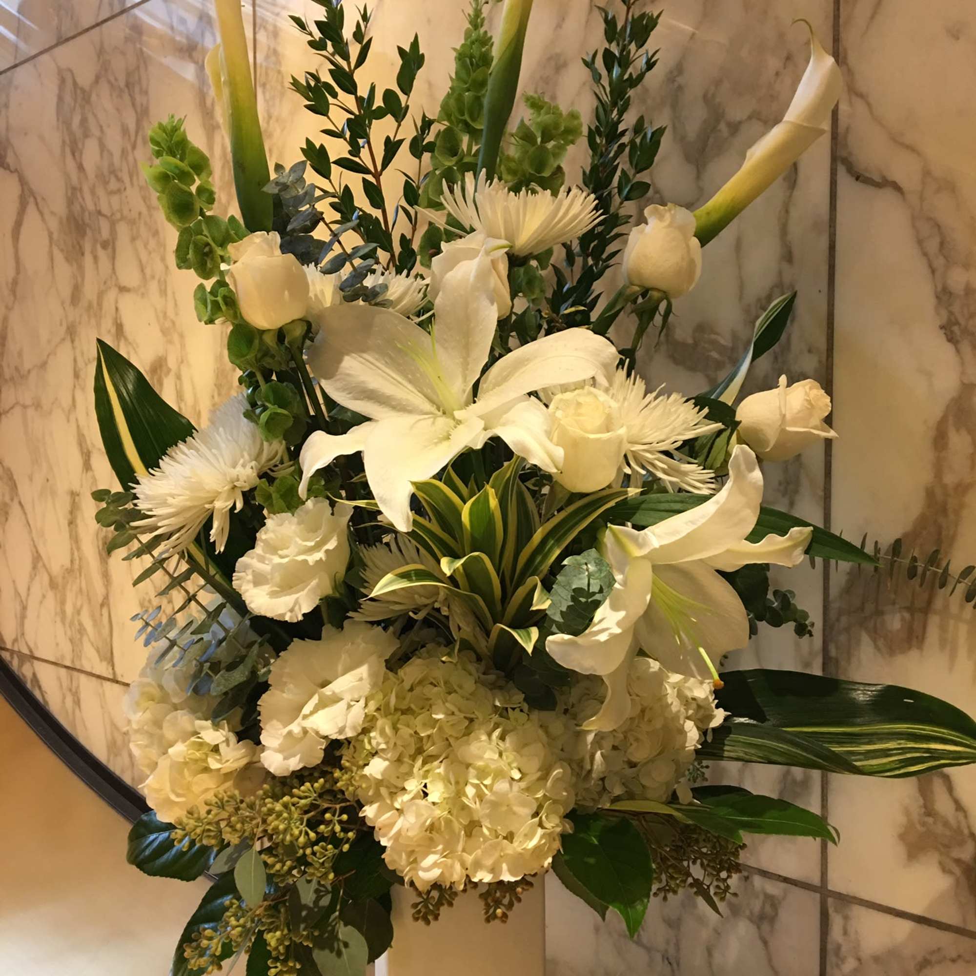 White floral arrangement in a tall pedestal vase