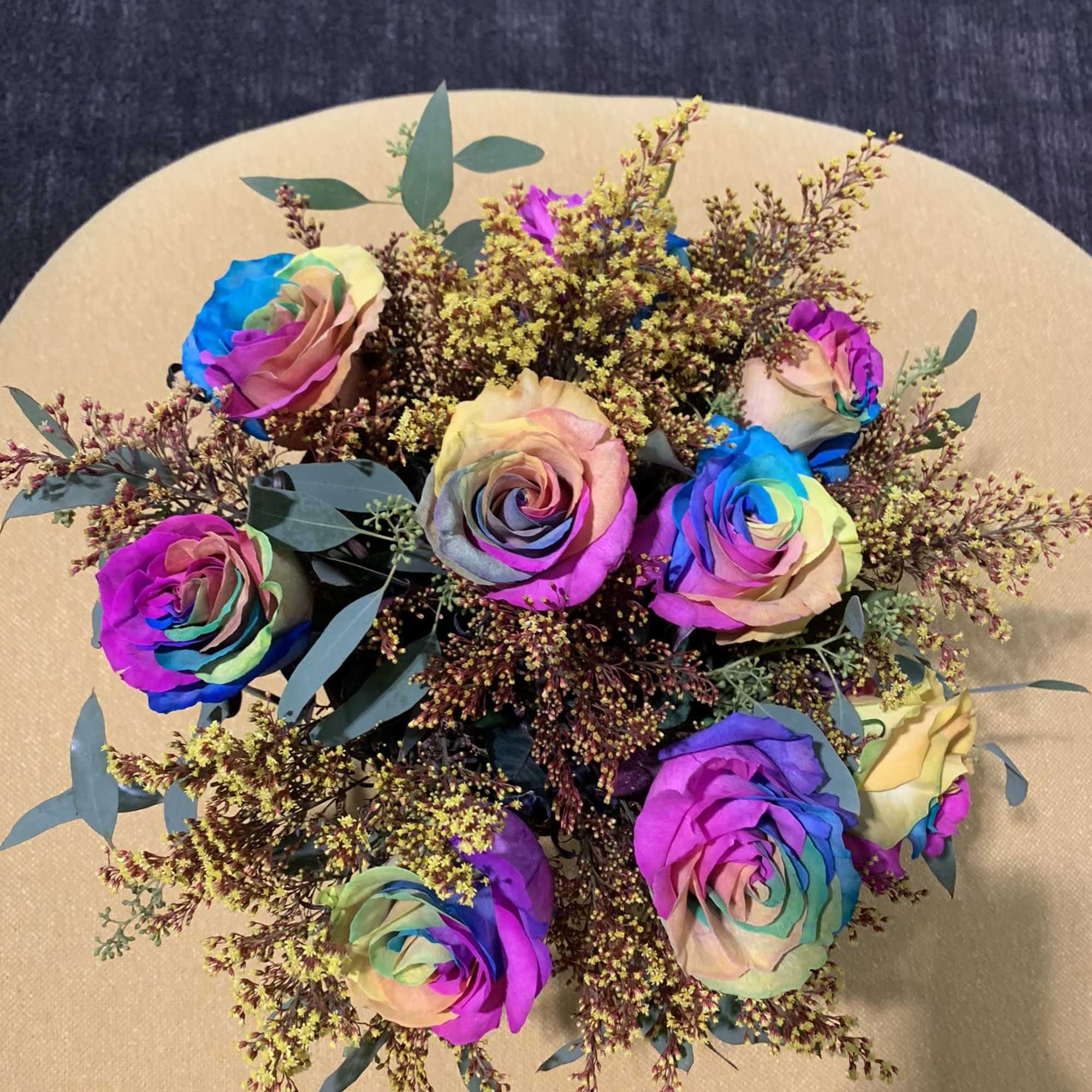 Bouquet of rainbow-colored roses with airy filler flowers