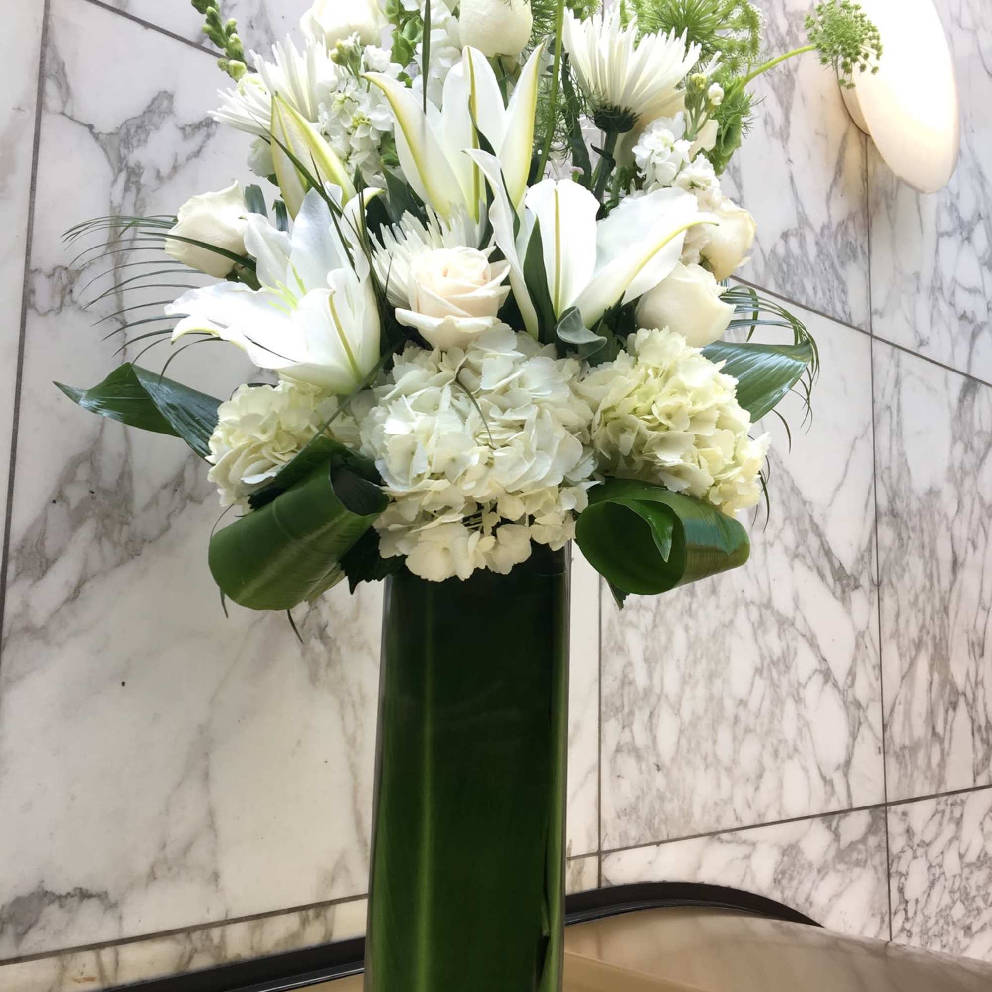White floral arrangement in a tall green vase, photo 2 of 3
