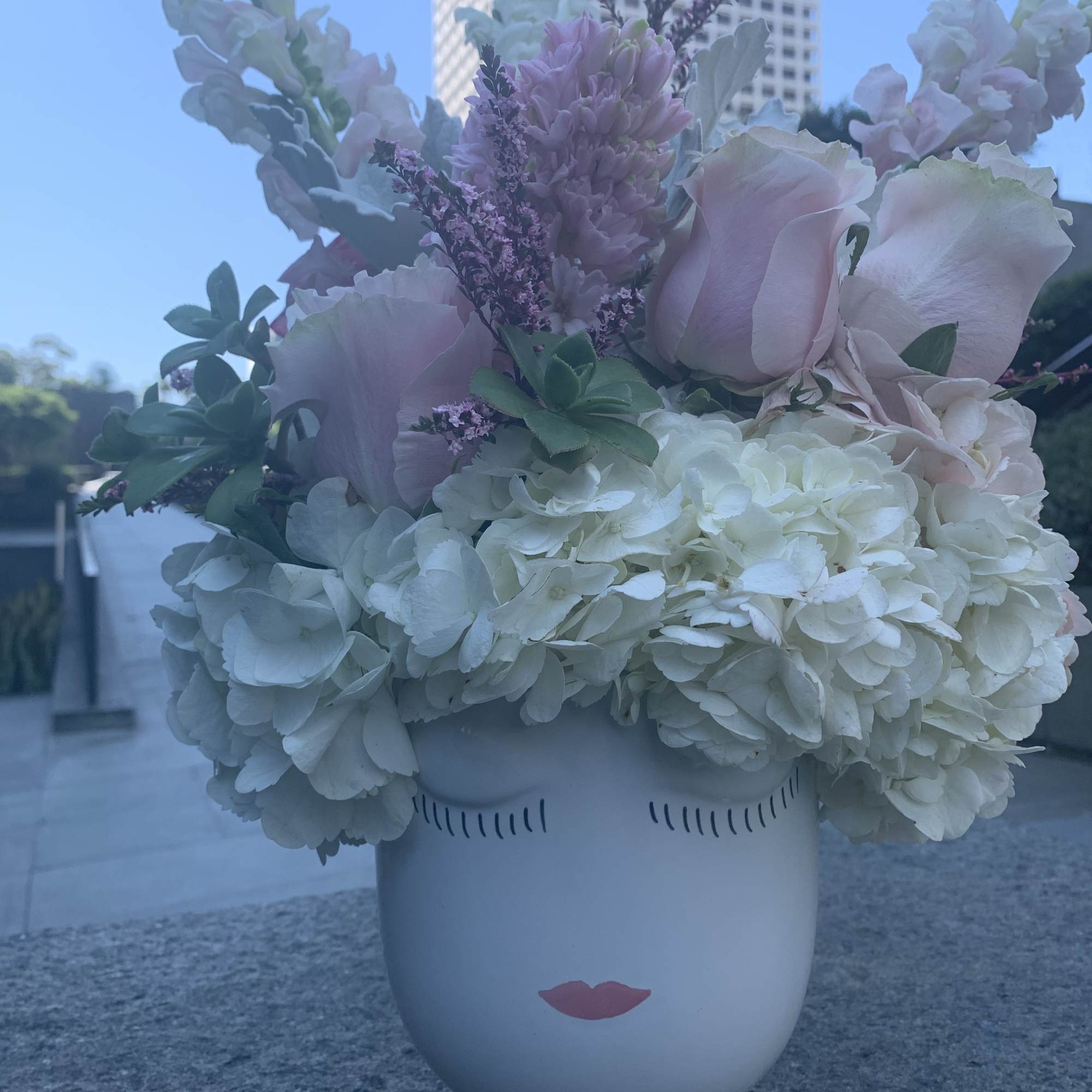 Pastel flower arrangement in a white face vase
