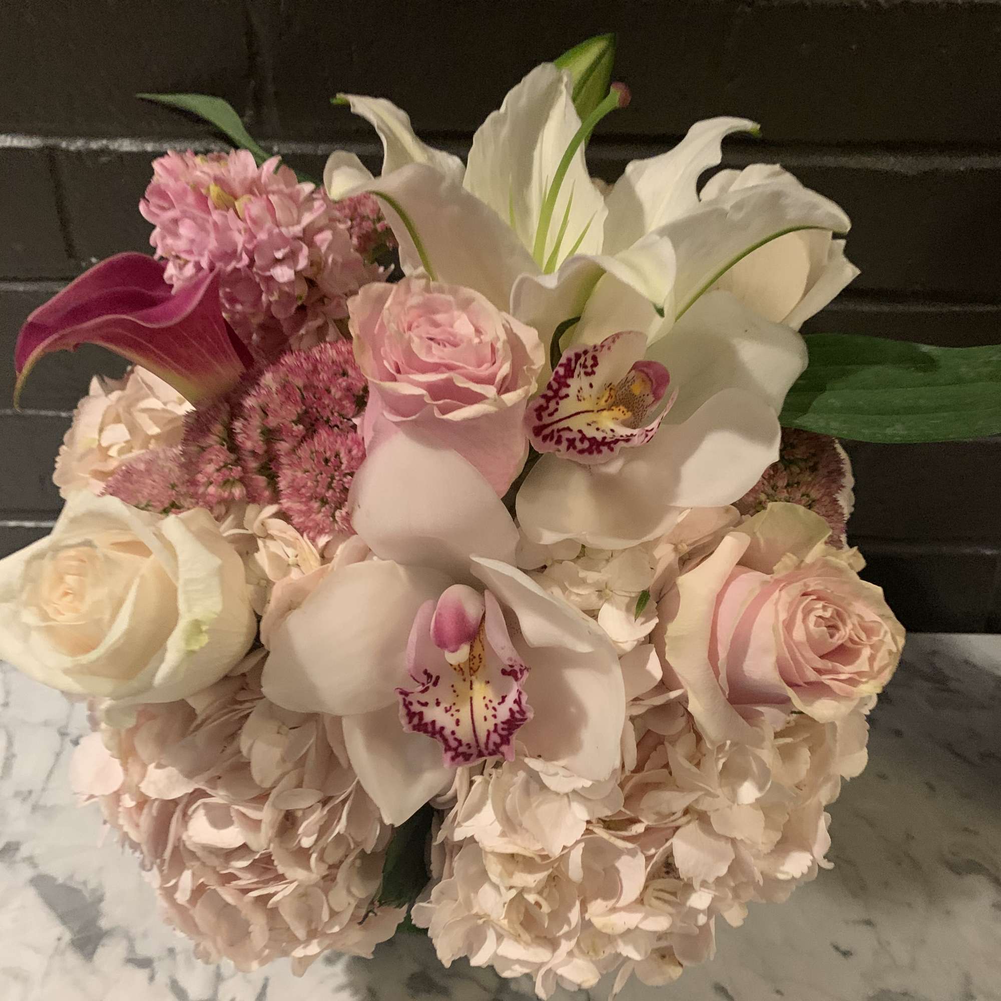 Pink and white bouquet with roses, lilies, orchids, and hydrangeas