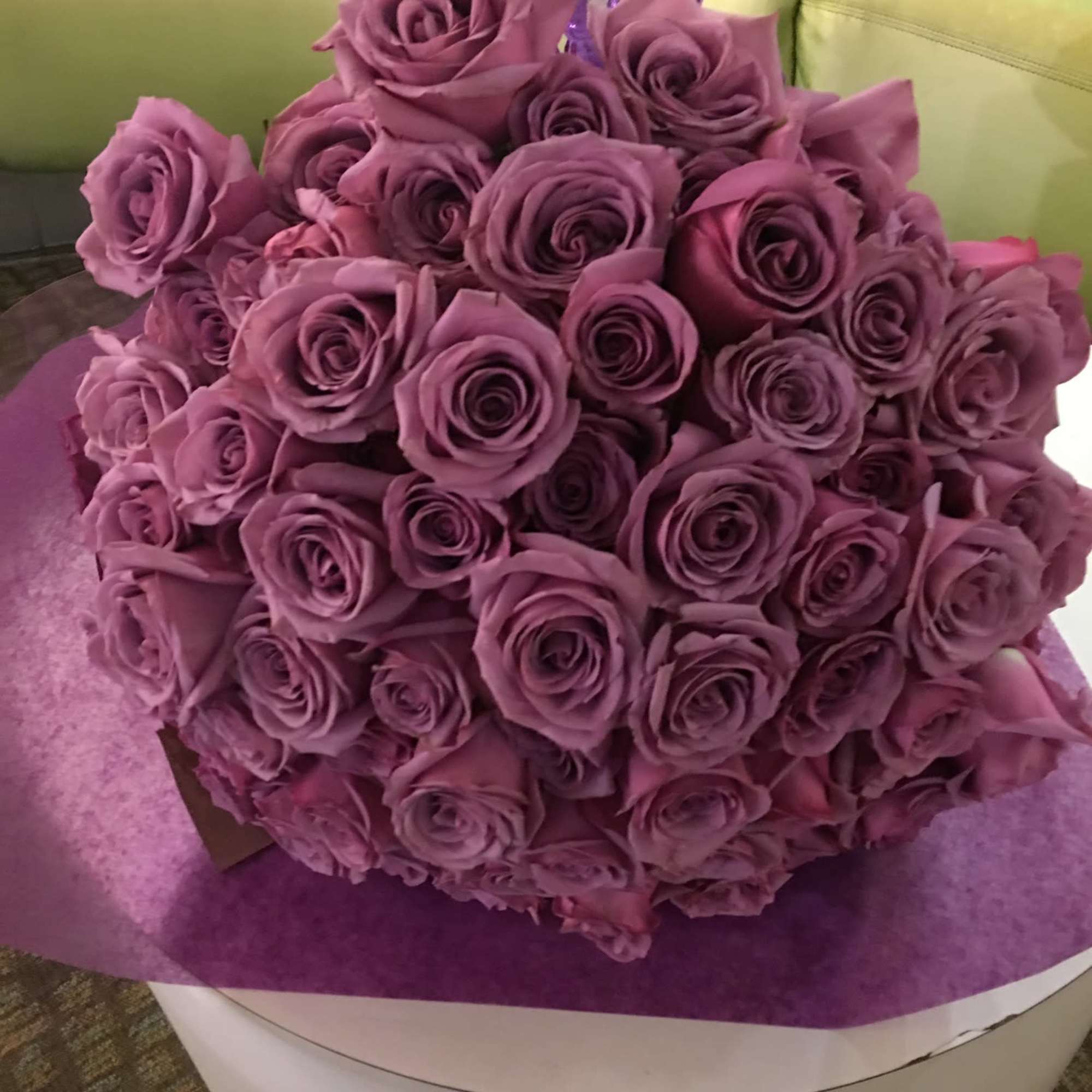 Bouquet of purple roses wrapped in purple paper
