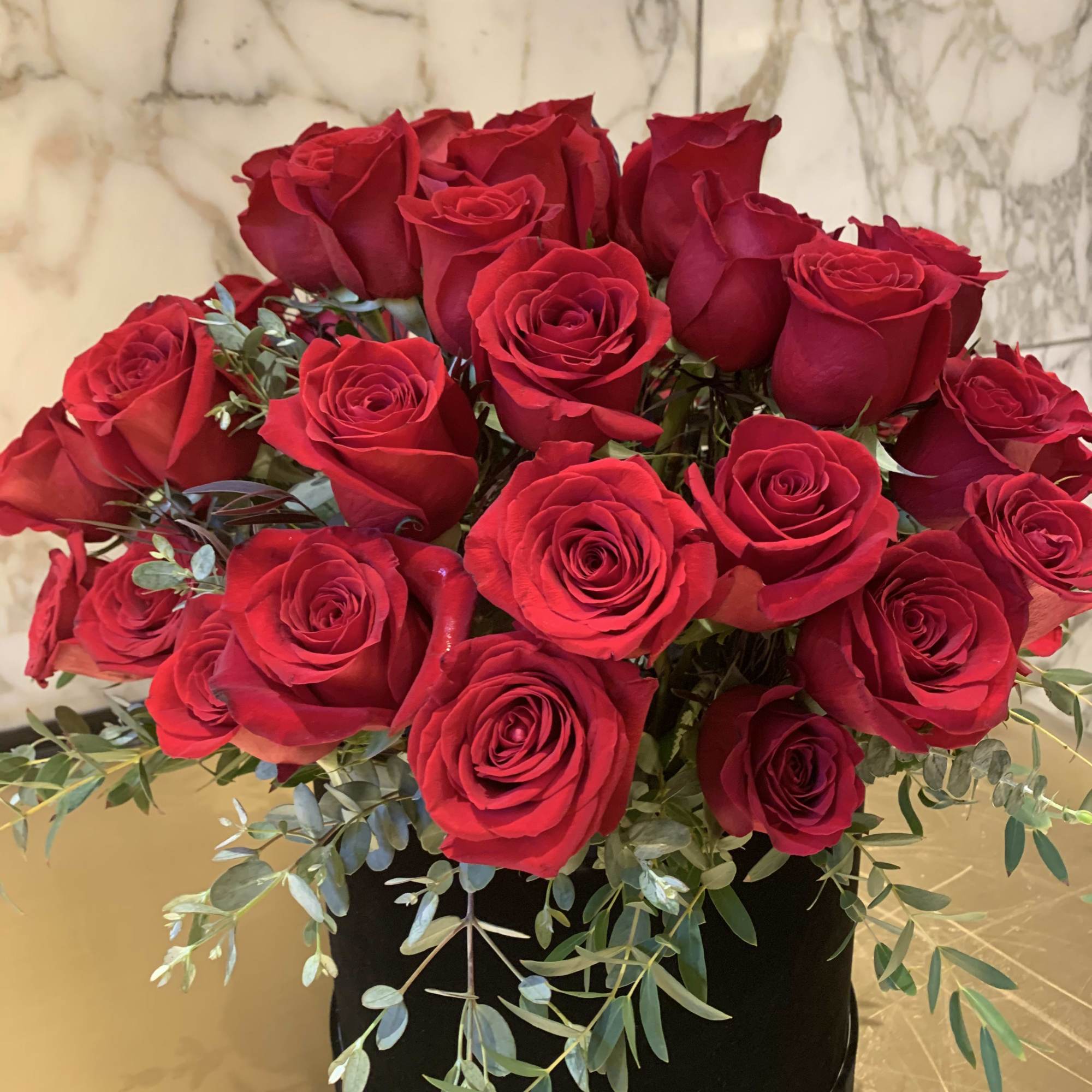 Bouquet of red roses in a black round box