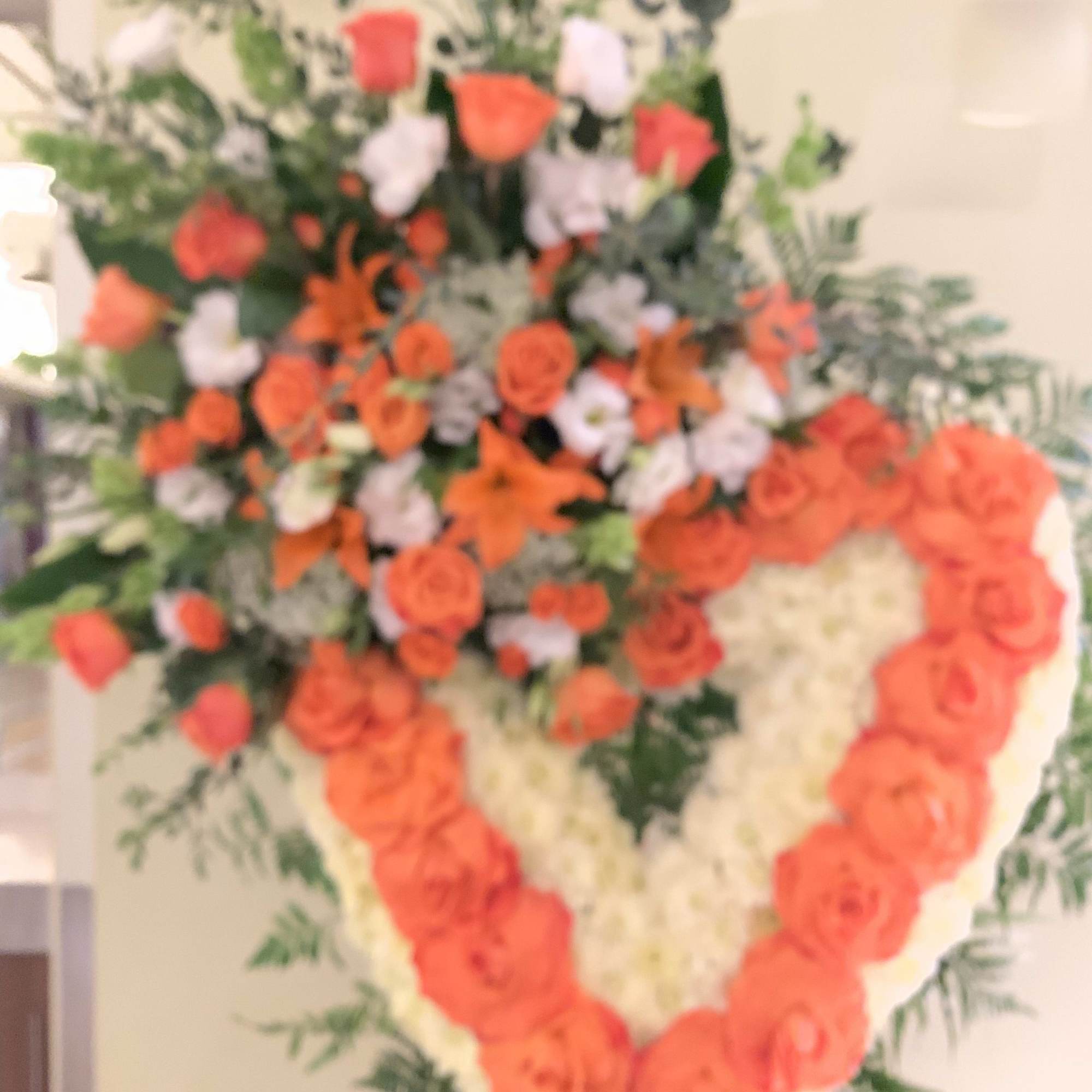 Heart-shaped floral spray with orange and white roses