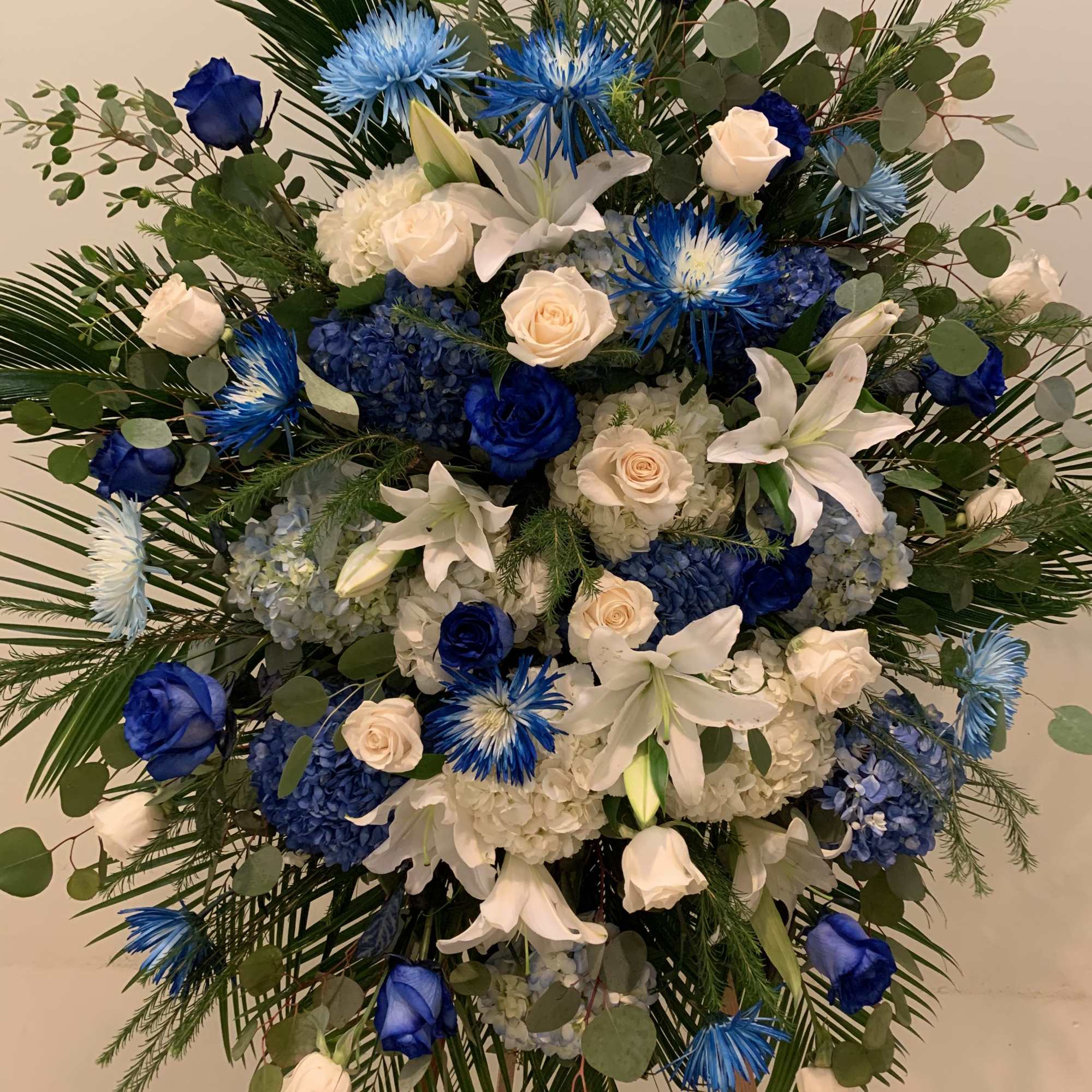 Large blue and white floral standing spray on an easel