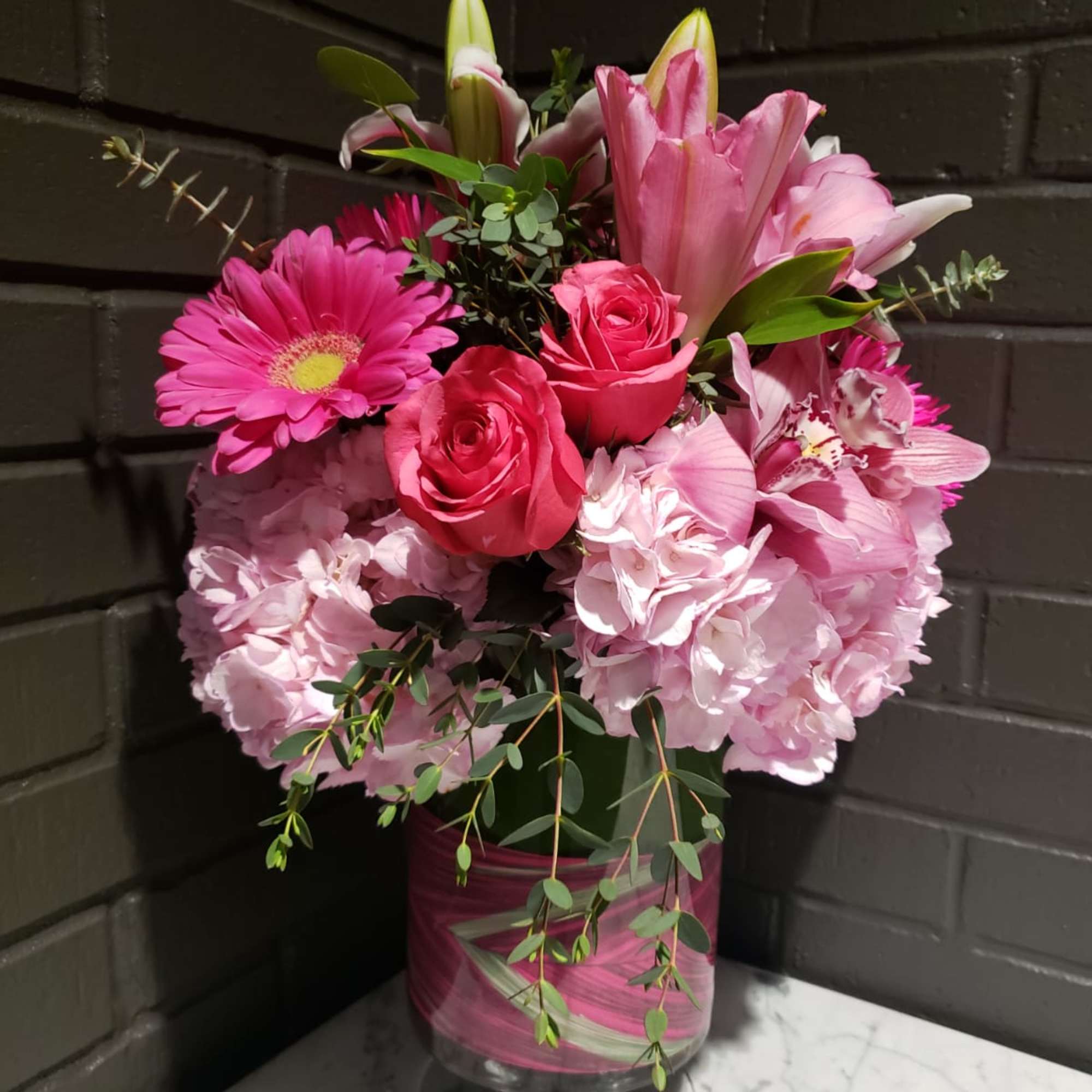 Pink mixed flower arrangement in a glass vase