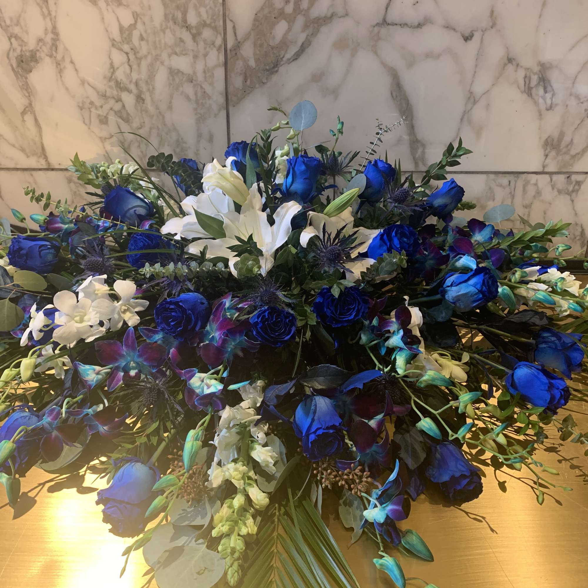 Large blue and white floral arrangement with roses and lilies