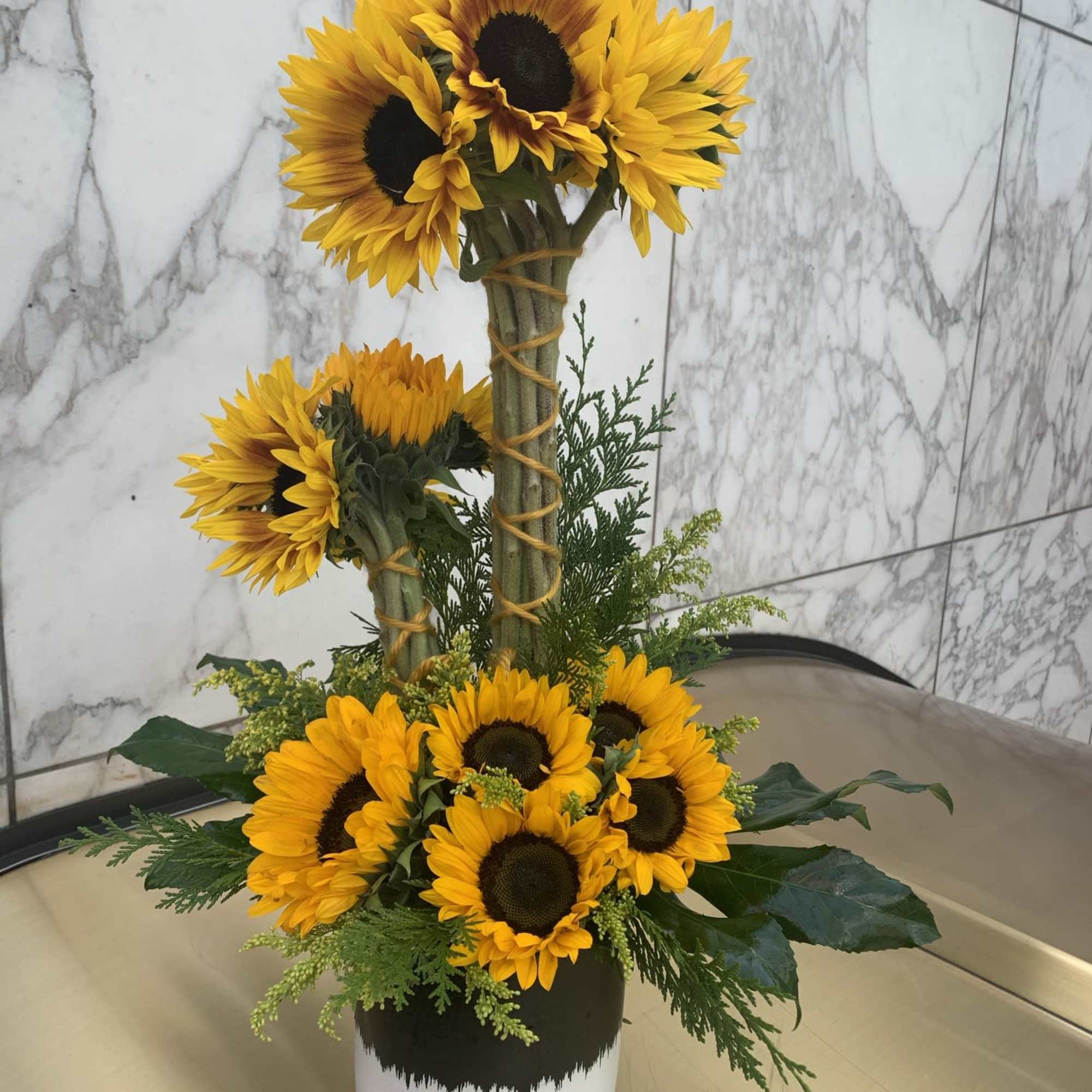 Sunflower arrangement in a black-and-white container