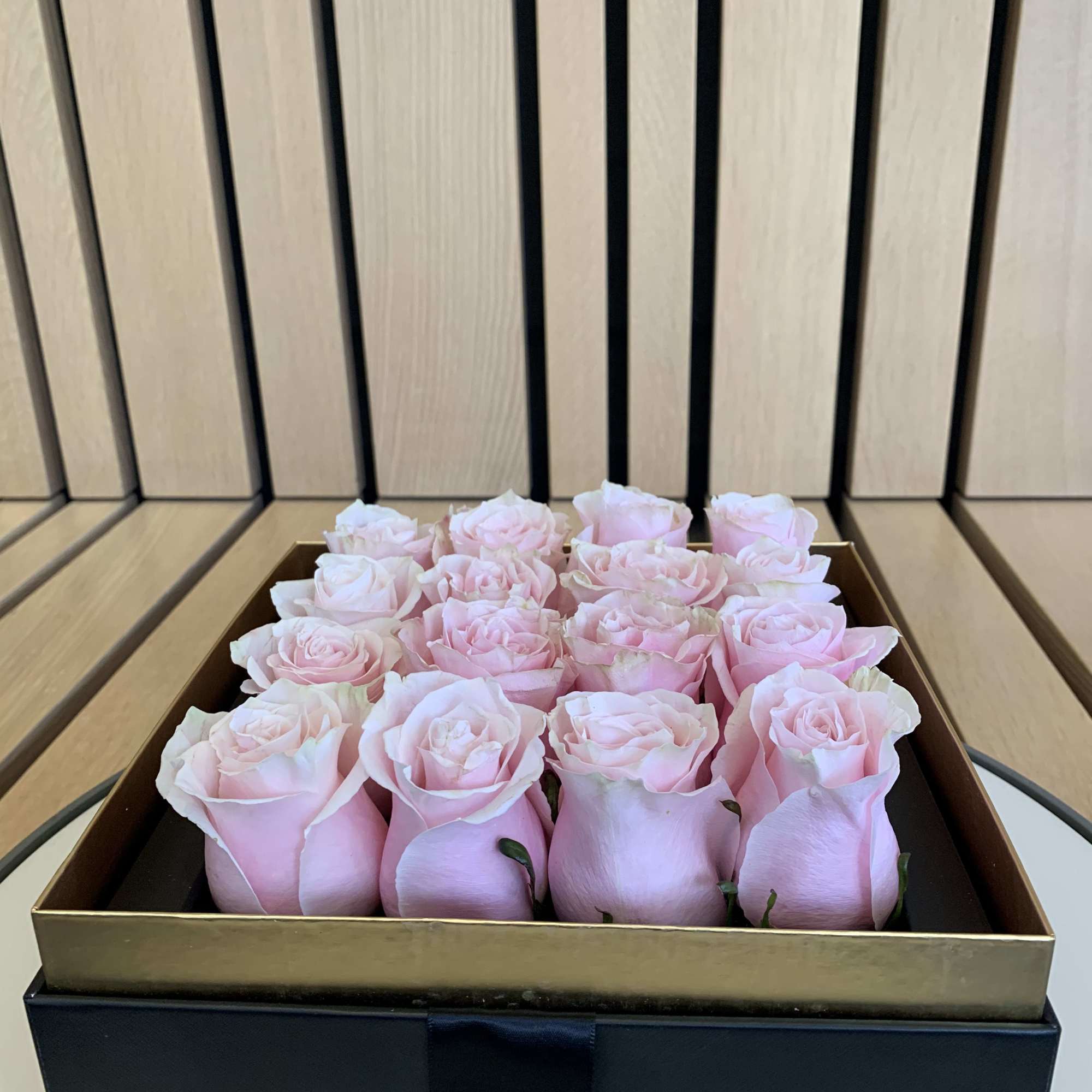 Boxed arrangement of pale pink roses in a black gift box