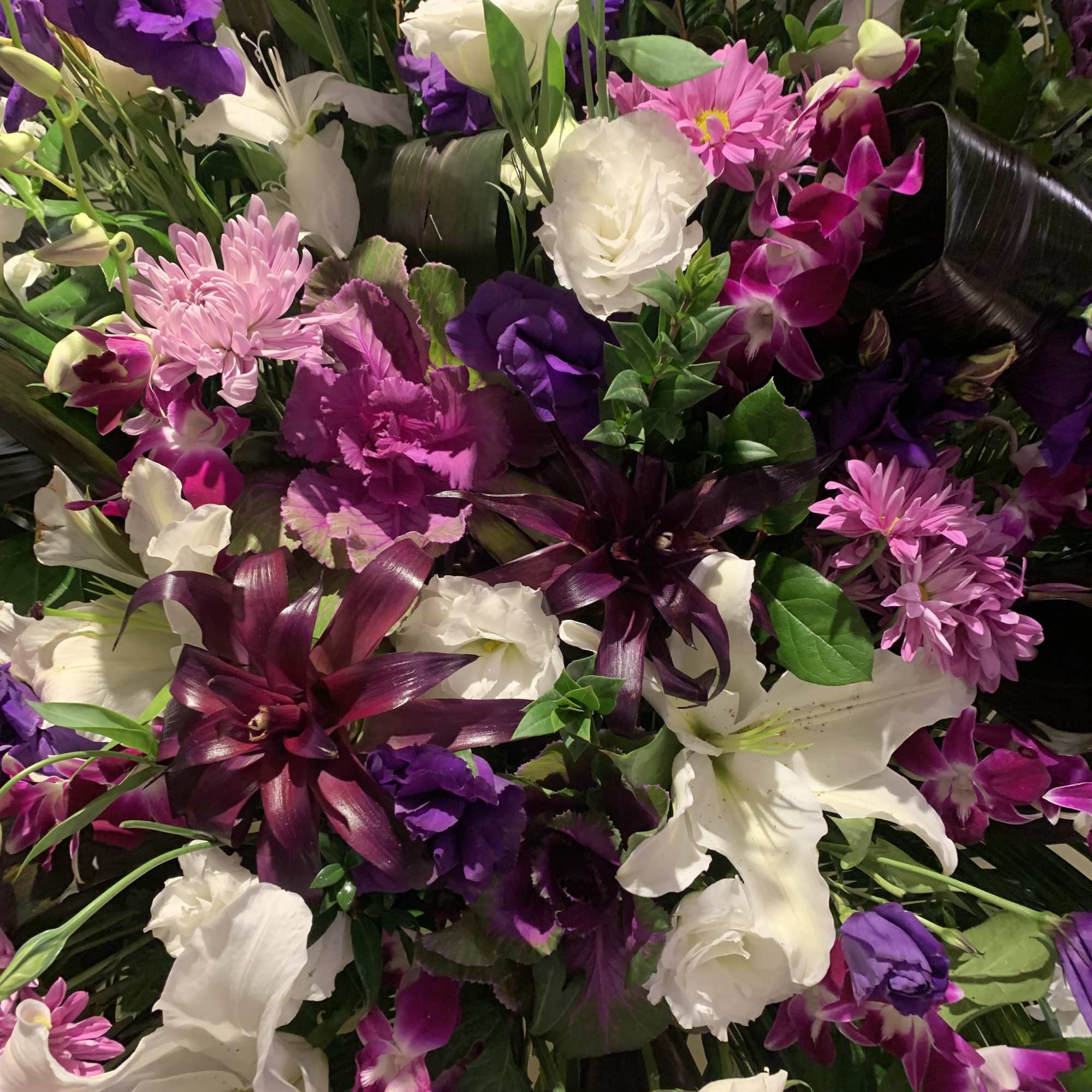 Mixed bouquet of white lilies, purple orchids, and pink chrysanthemums