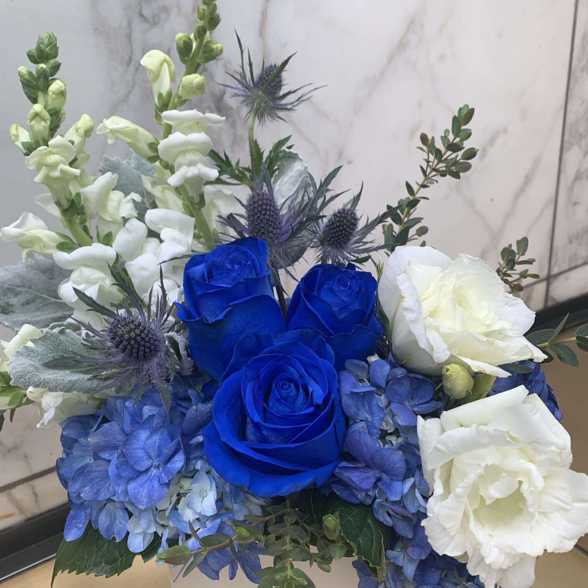 Blue and white roses with blue hydrangeas in a white box