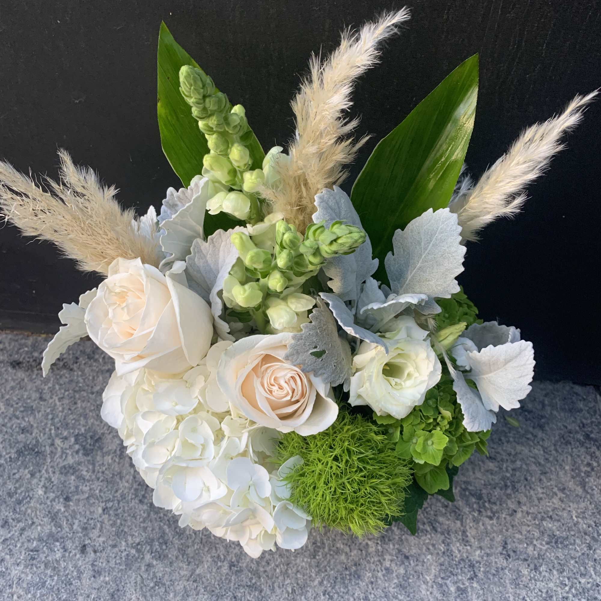White and pale peach bouquet with green accents and feathery plumes