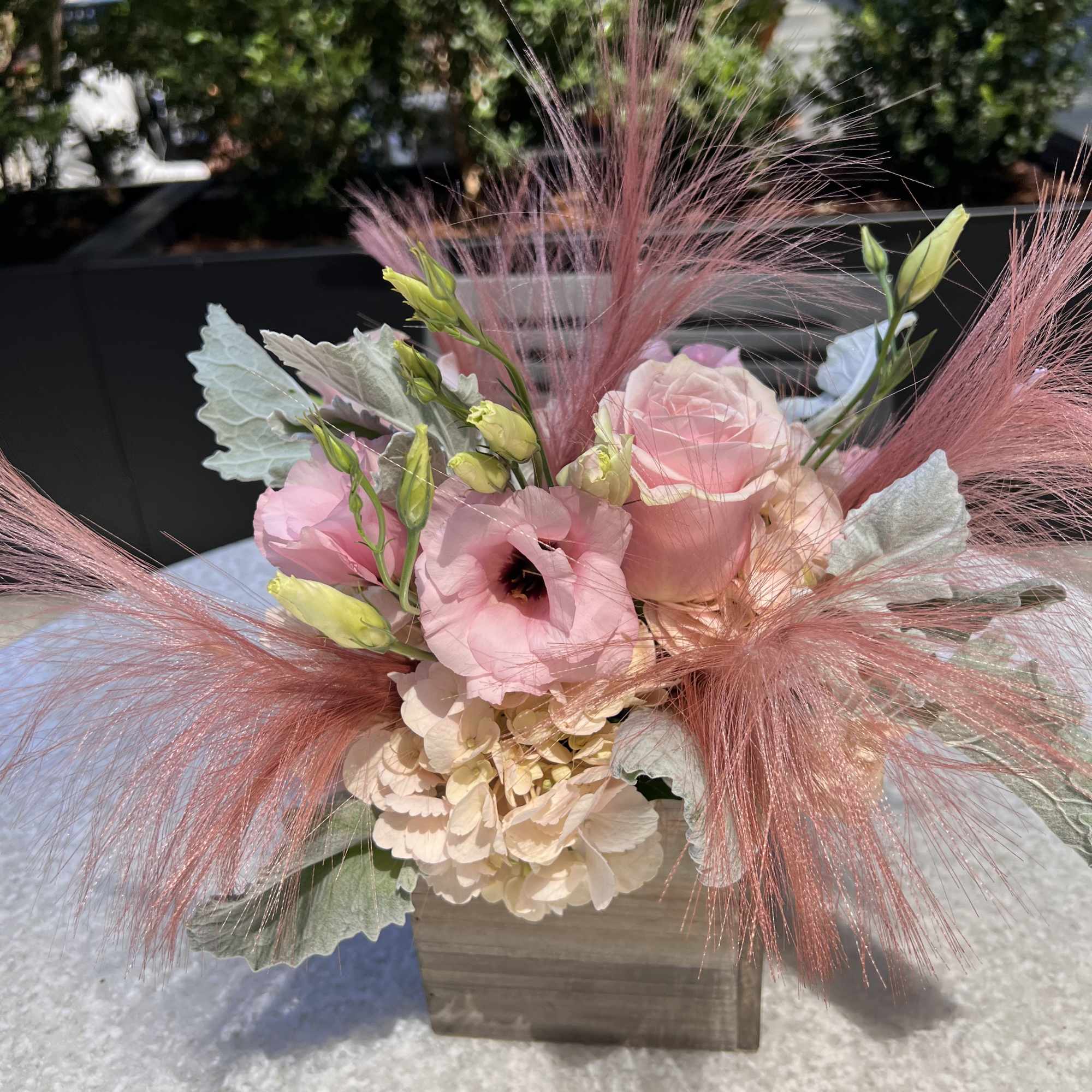 Pink and cream floral arrangement in a wooden box with airy pink accents