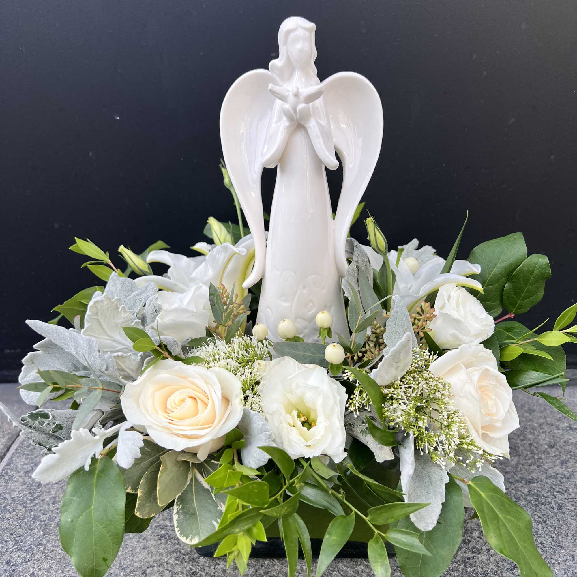 White angel figurine surrounded by white roses and greenery, photo 3 of 4