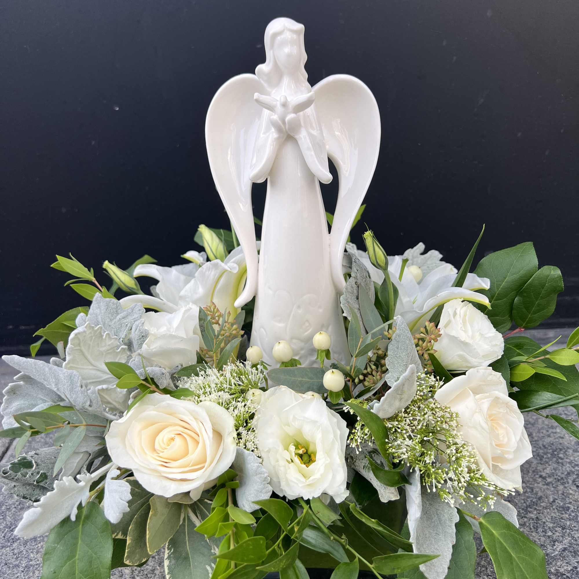 White angel figurine surrounded by white roses and greenery, photo 4 of 4