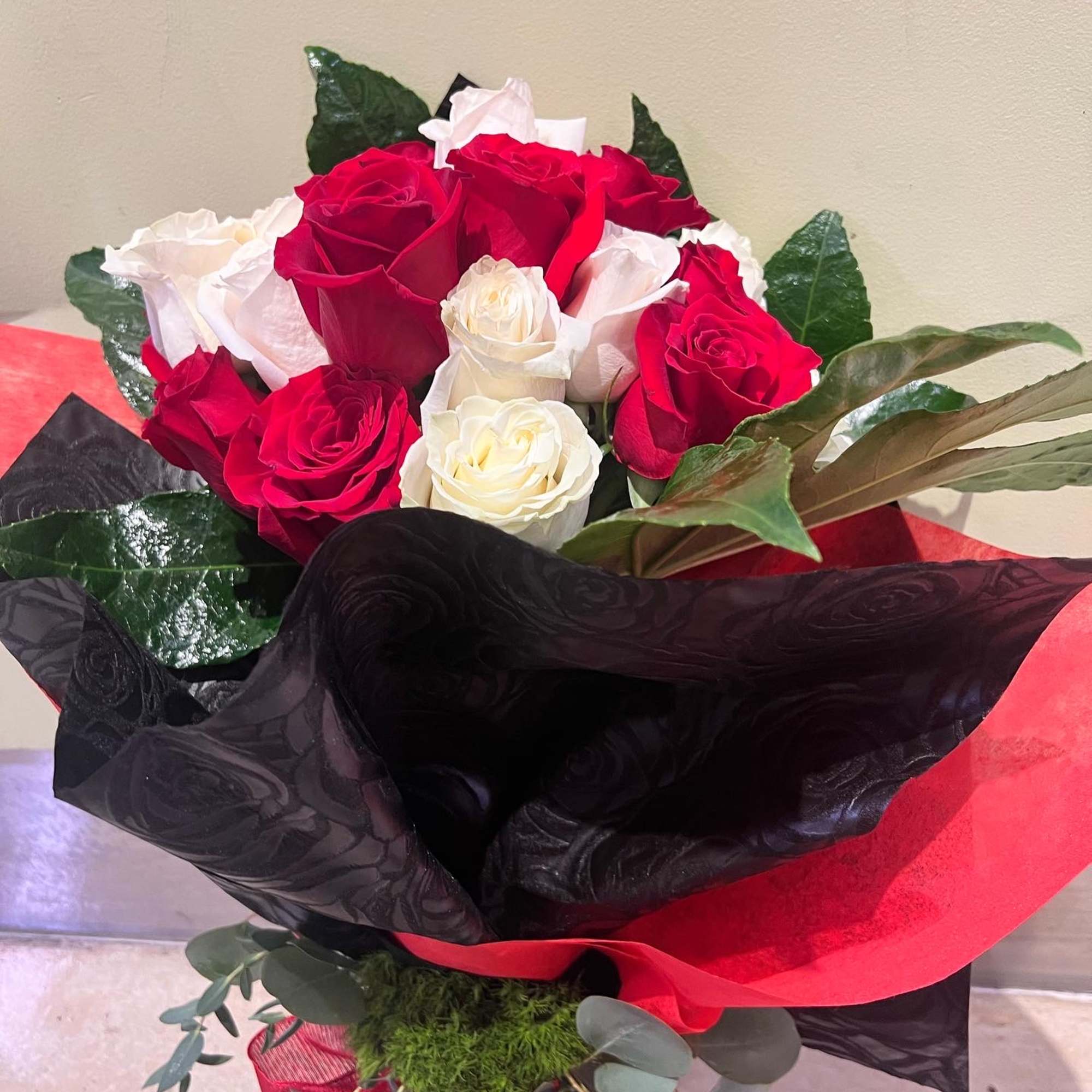 Bouquet of red and white roses wrapped in black and red paper